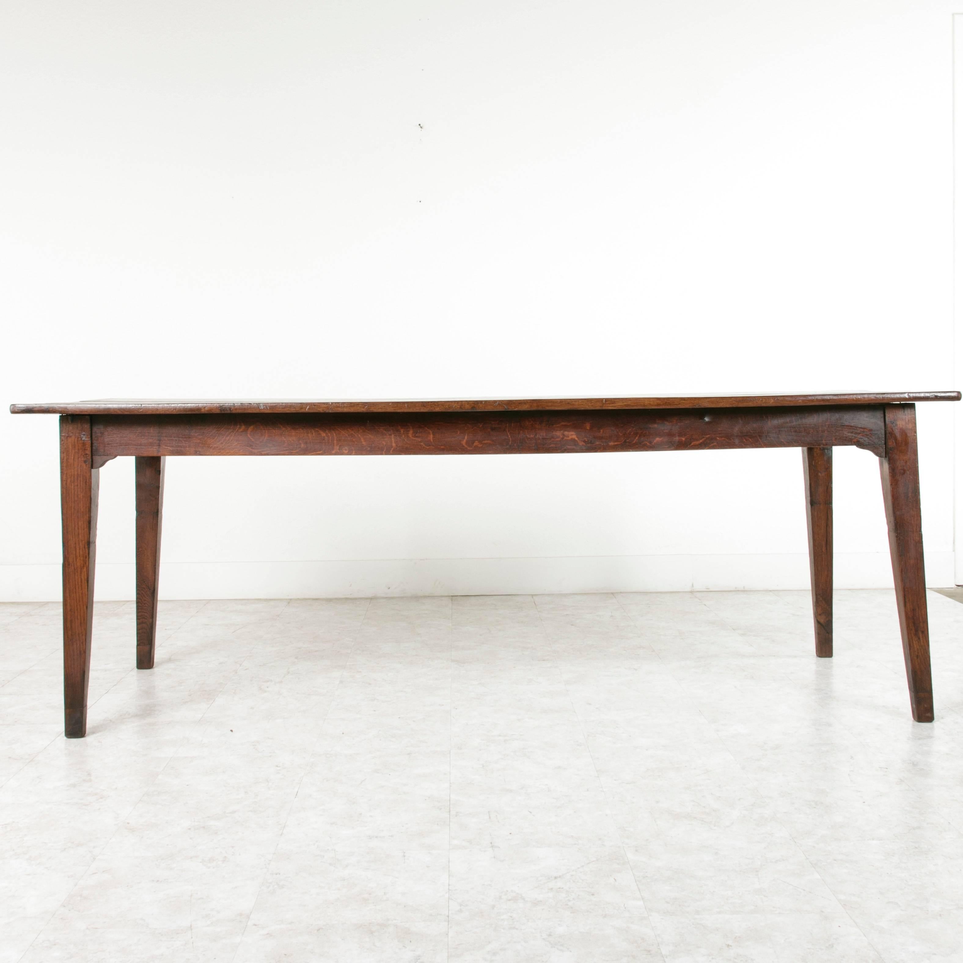 This artisan made farm table is made of solid, hand pegged French oak. This piece's simple elegant lines will blend with modern and traditional decors, while the age of its wood gives it a wonderfully warm feeling. At more than seven feet in length,