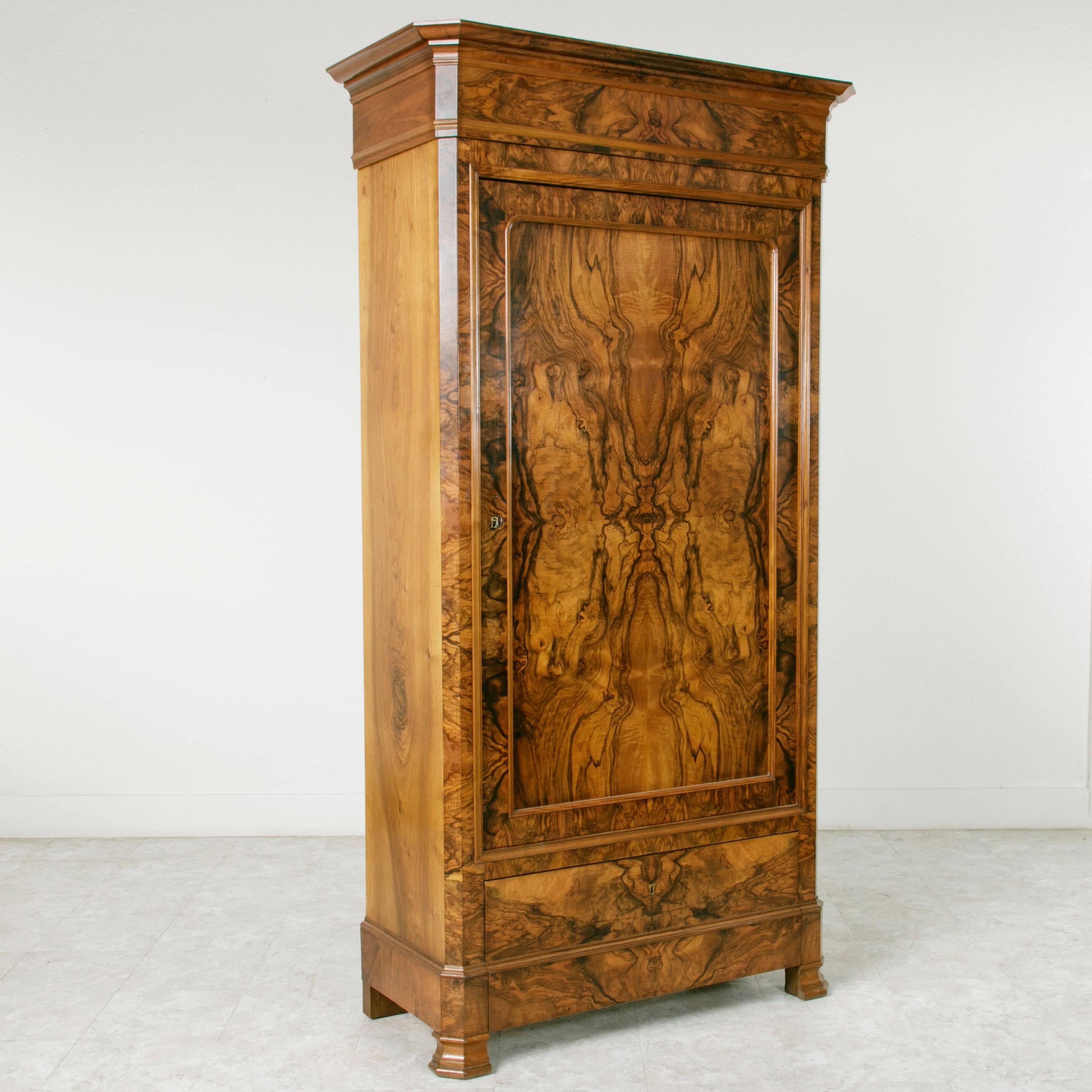 A rare show stopper, this Louis Philippe period bonnetiere features one large door and one drawer. The deep contrast of the burl on this piece combined with its magnificent butterfly effect make this armoire an outstanding example of the Louis