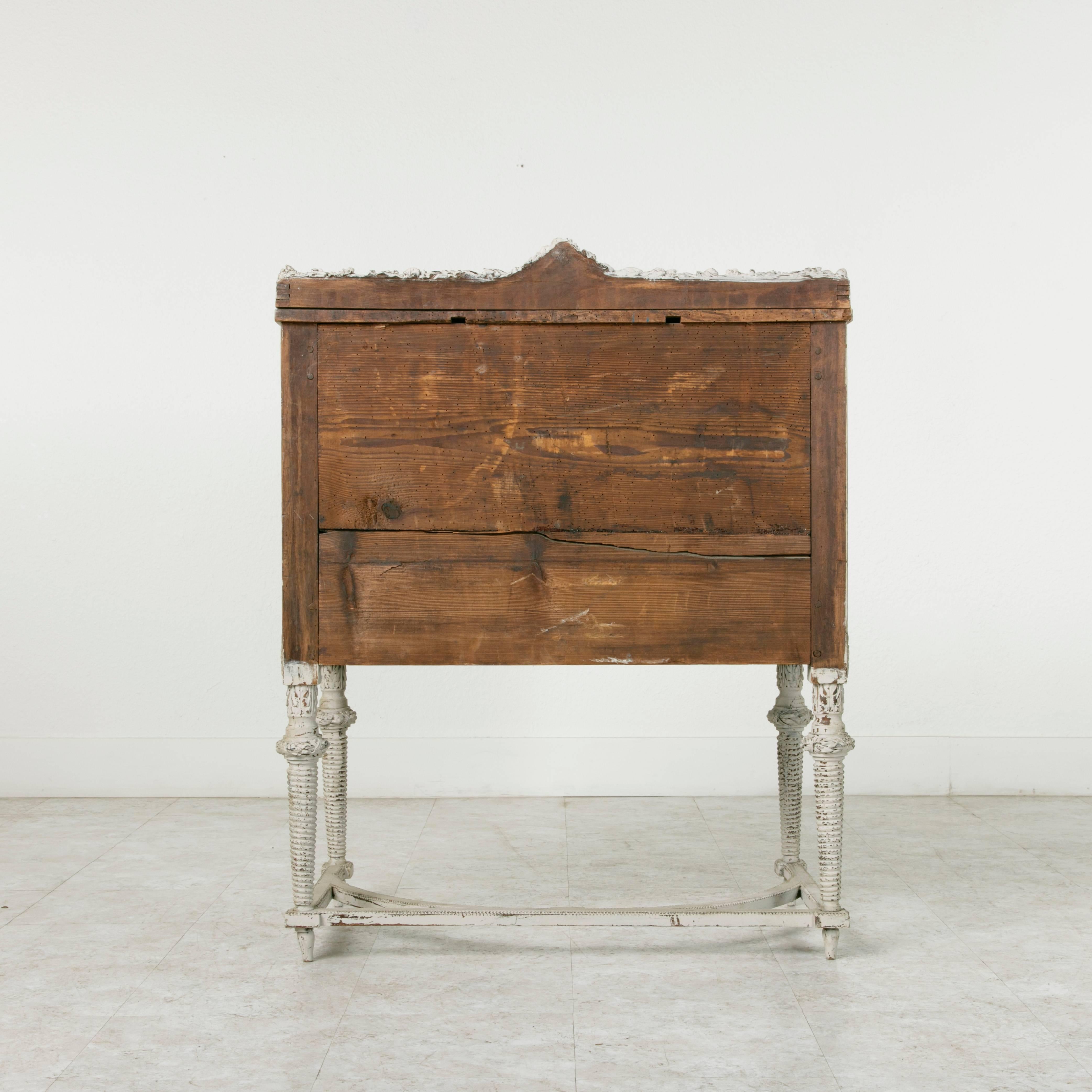 This exceptional rare Directoire period bureau de pente or writing desk features intricately executed Louis XVI motif carvings of bows, drapes, and ivy circling Directoire arrows. The drop down front opens to reveal an interior finished in leather