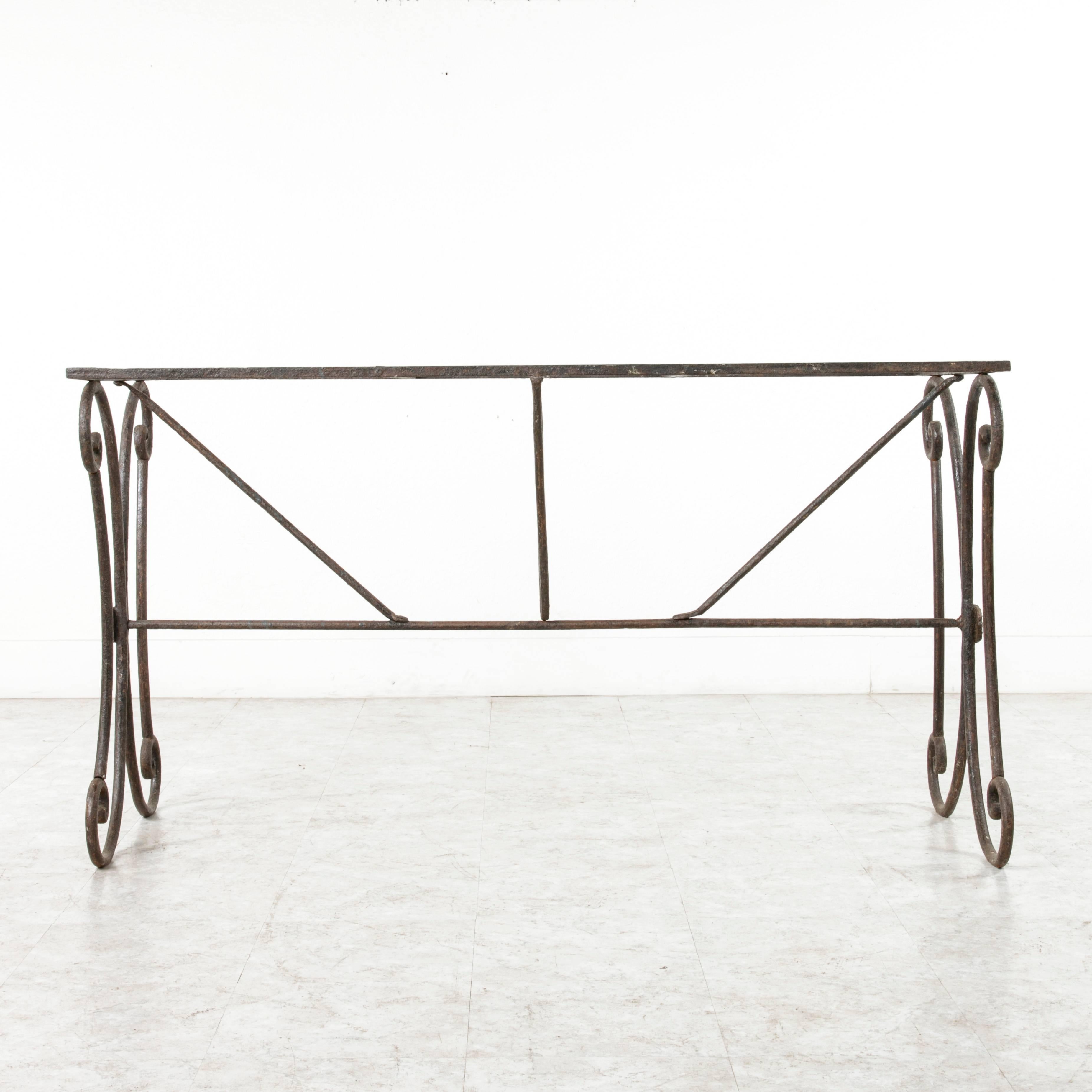 This handsomely aged solid and heavy iron table base would display beautifully with a glass, wood, or stone top. The opportunity to meld old and new styles is rare, and the beautifully curved sculptural sides of this piece combined with its thick,
