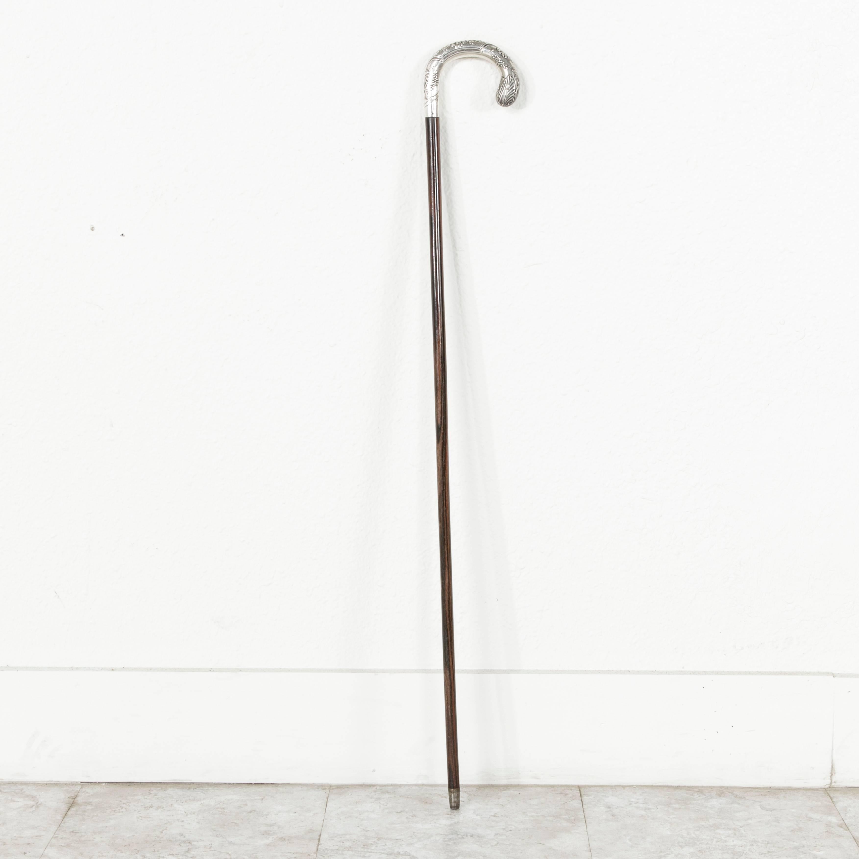 The elegant walking stick features a beautifully detailed silver plated handle with grapes and flowers. The slender palissander wooden stick has beautiful deeply contrasting heart grain lines, and it is tipped on the bottom with silver to protect