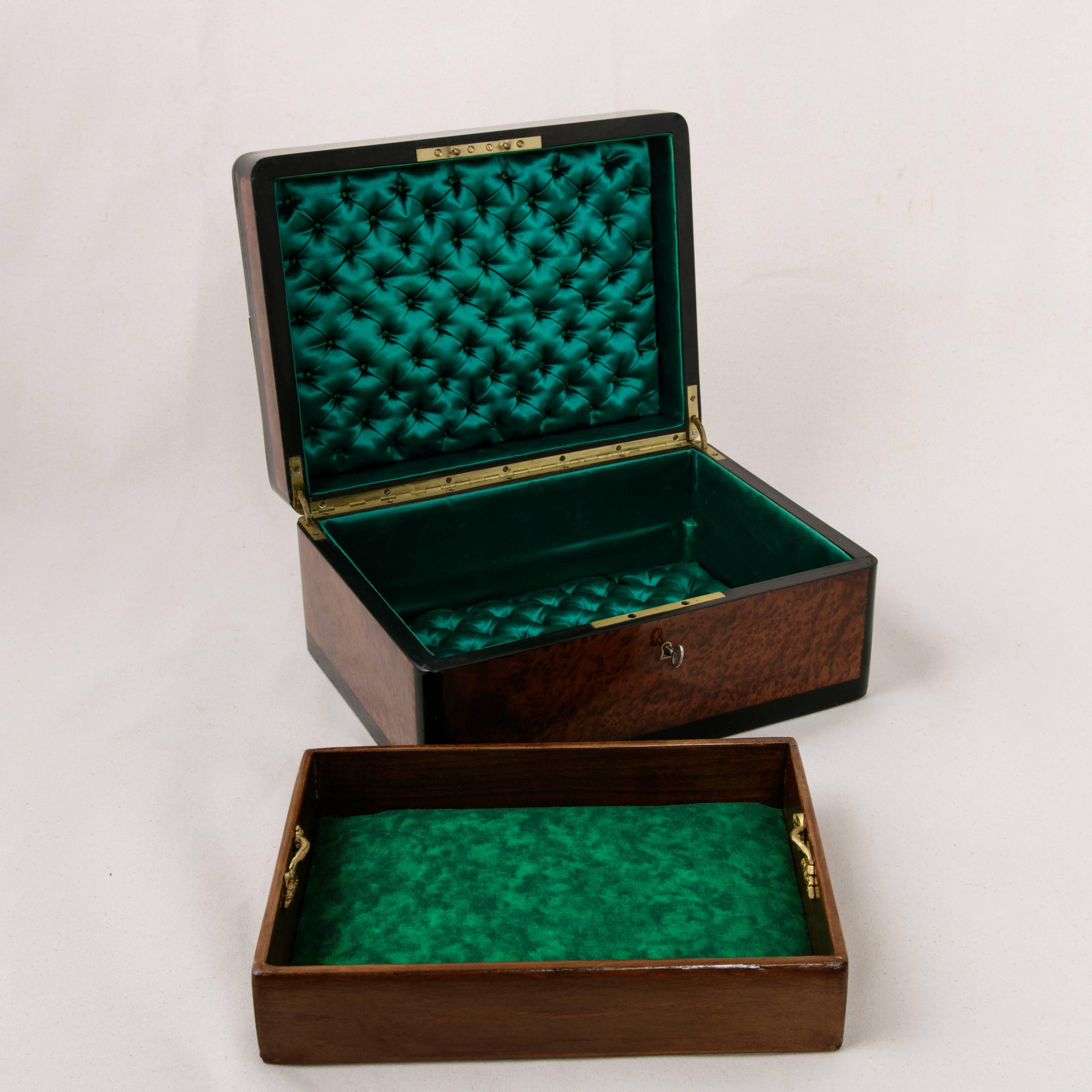 This unusually large decorative marquetry box was created during the reign of Napoleon III in France. A handsome and sleek geometric inlaid design of contrasting bronze, ivory and black lacquer surrounds its thuya wood exterior. The interior is