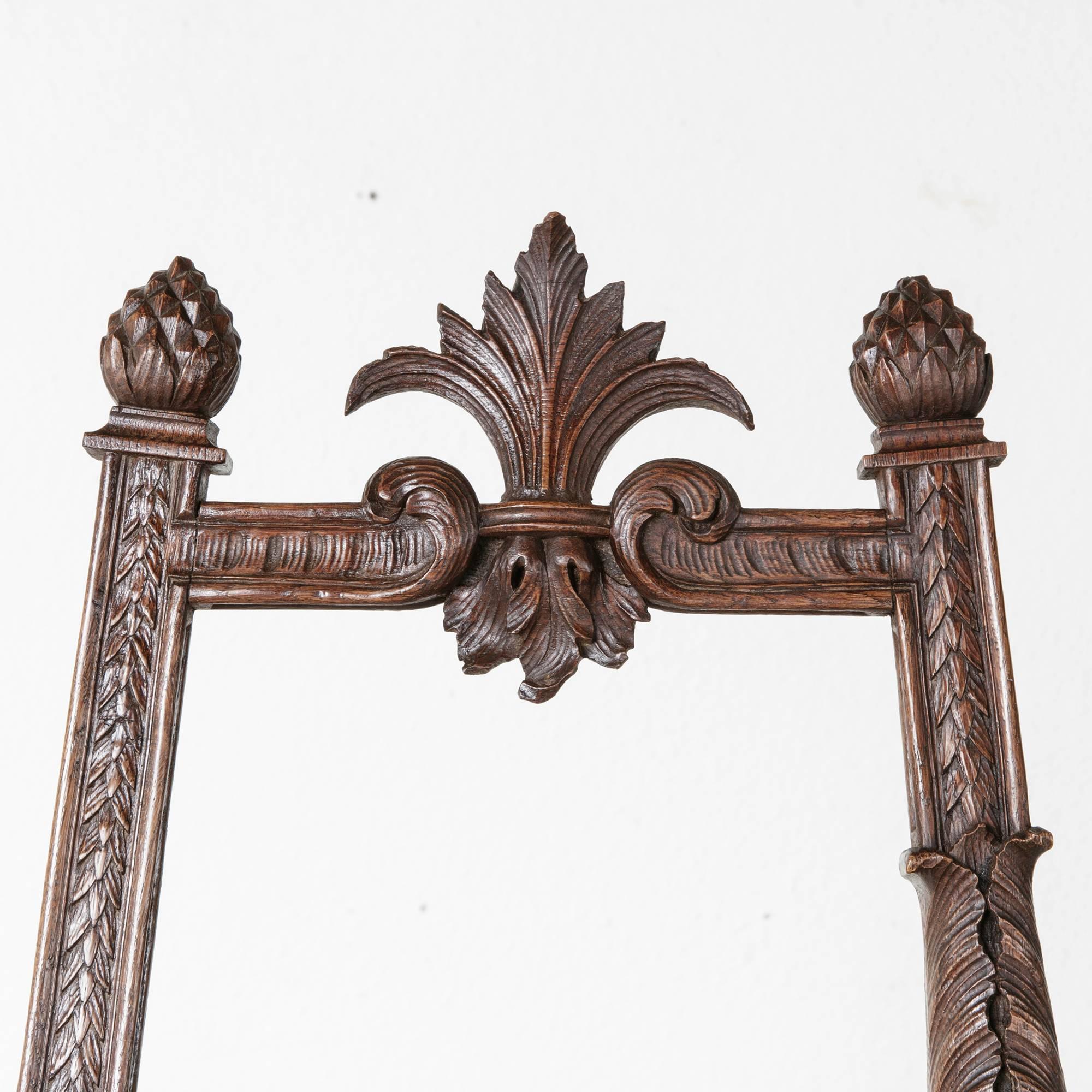 This unique floor easel of solid walnut features elaborately hand-carved pineapples, acanthus, and rosettes. With charming asymmetrically carved elements, this floor easel will make an excellent formal display for artwork or a sign in a floating