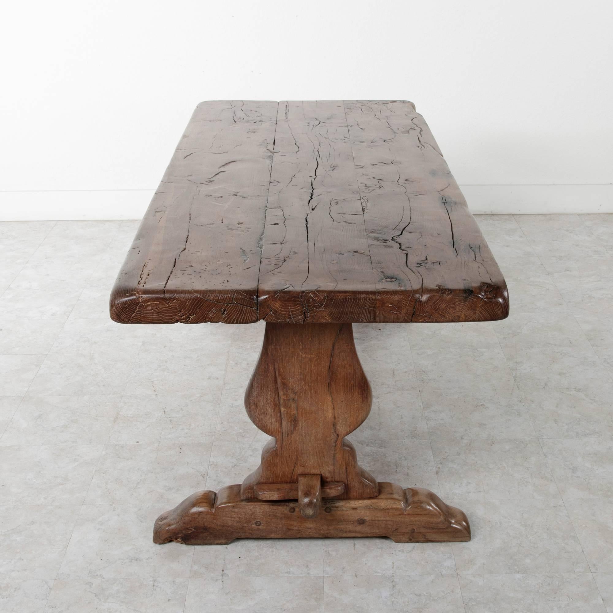 This beautifully aged oak monastery table was constructed from 18th century beams of wood, giving it a spectacular aged feel. Found in Normandy, this table's trestle design allows for two to three seats along each side and one at each end. The top