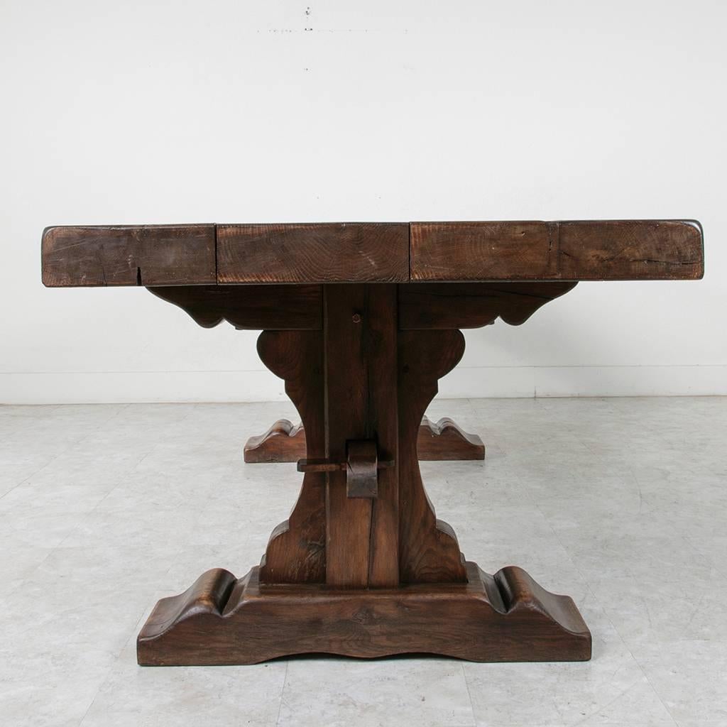 Created by artisans in Normandy, this hand pegged oak monastery trestle table was constructed of wood from 18th century beams. With a massive top of 4