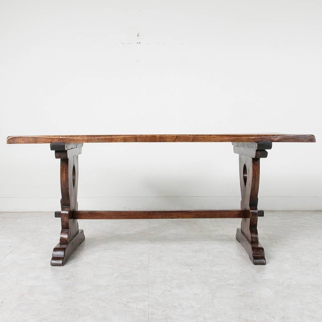 An unusual smaller scale with a grand presence, this solid beechwood monastery table was created by artisans in the Normandy region of France in the early part of the 20th century. This piece's sturdy handmade trestle construction will last for
