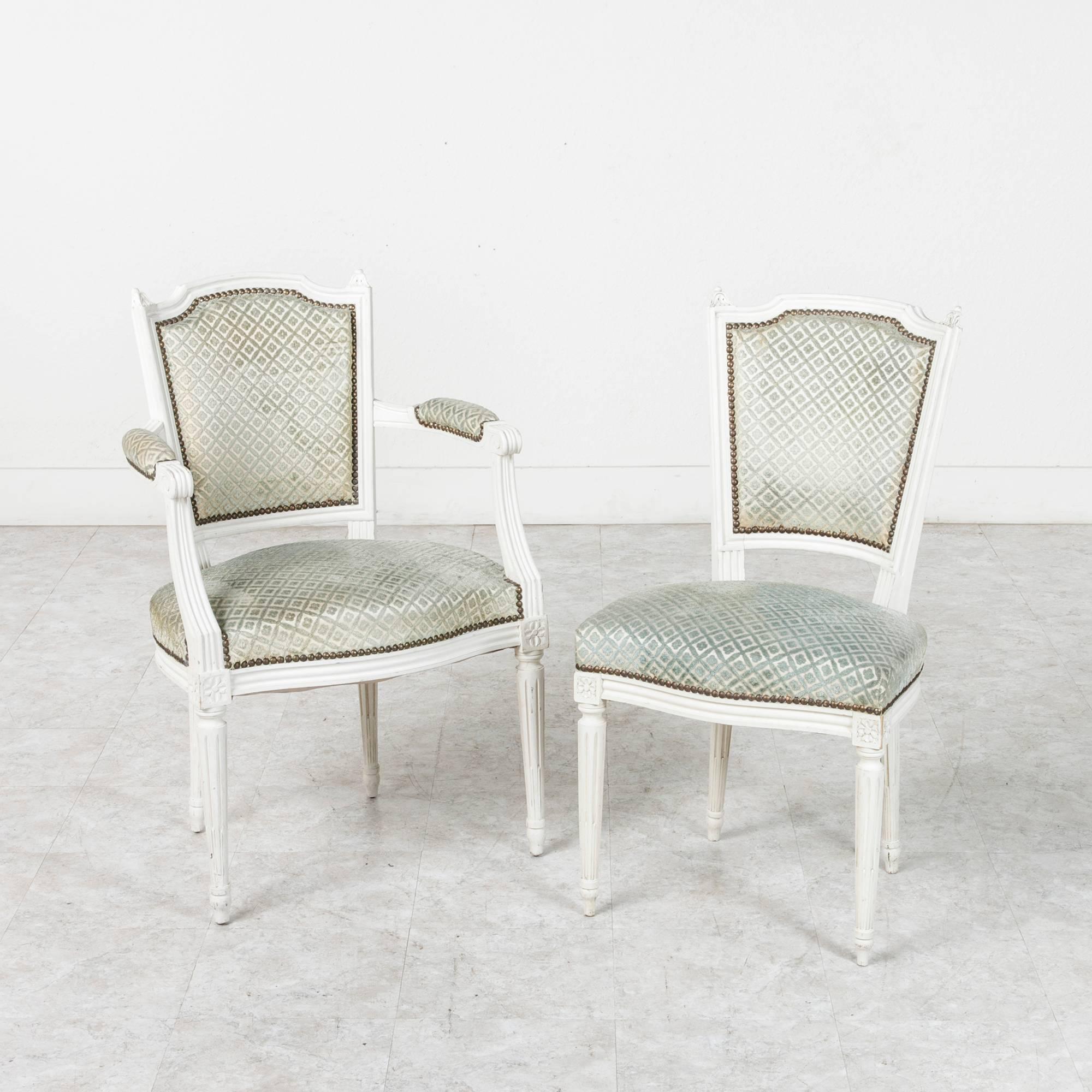 This elegant set of Louis XVI style dining chairs is constructed of solid wood and finished in a beautifully patinated matte white with a faint distressing at the edges. Including two armchairs and four side chairs, this set will make a classical