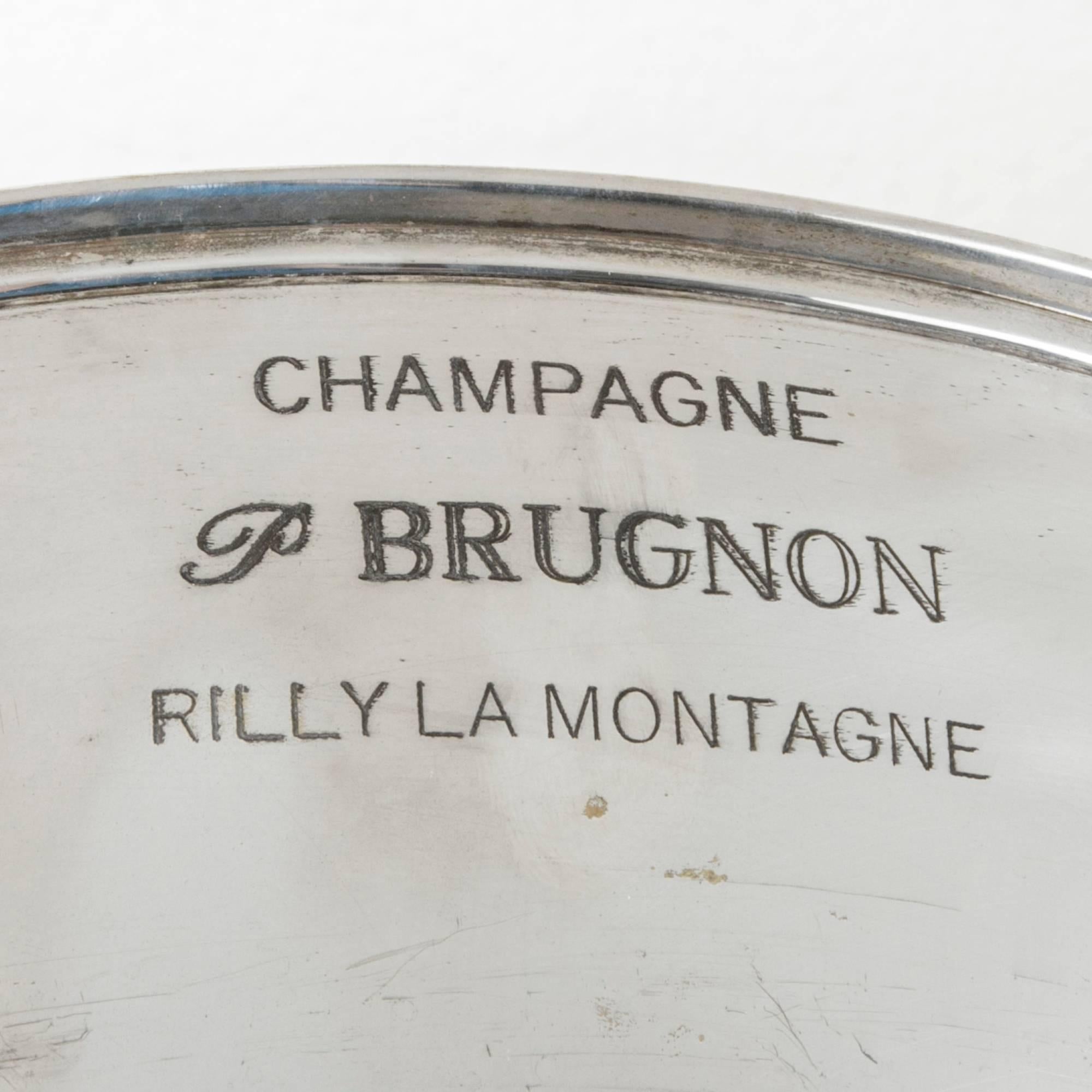 This large hotel champagne bucket is designed to chill up to six bottles at a time and is engraved with the mark of the champagne domain, P. Brugnon, Rilly La Montagne. An exquisite bar piece, this silver bowl will display beautifully on a
