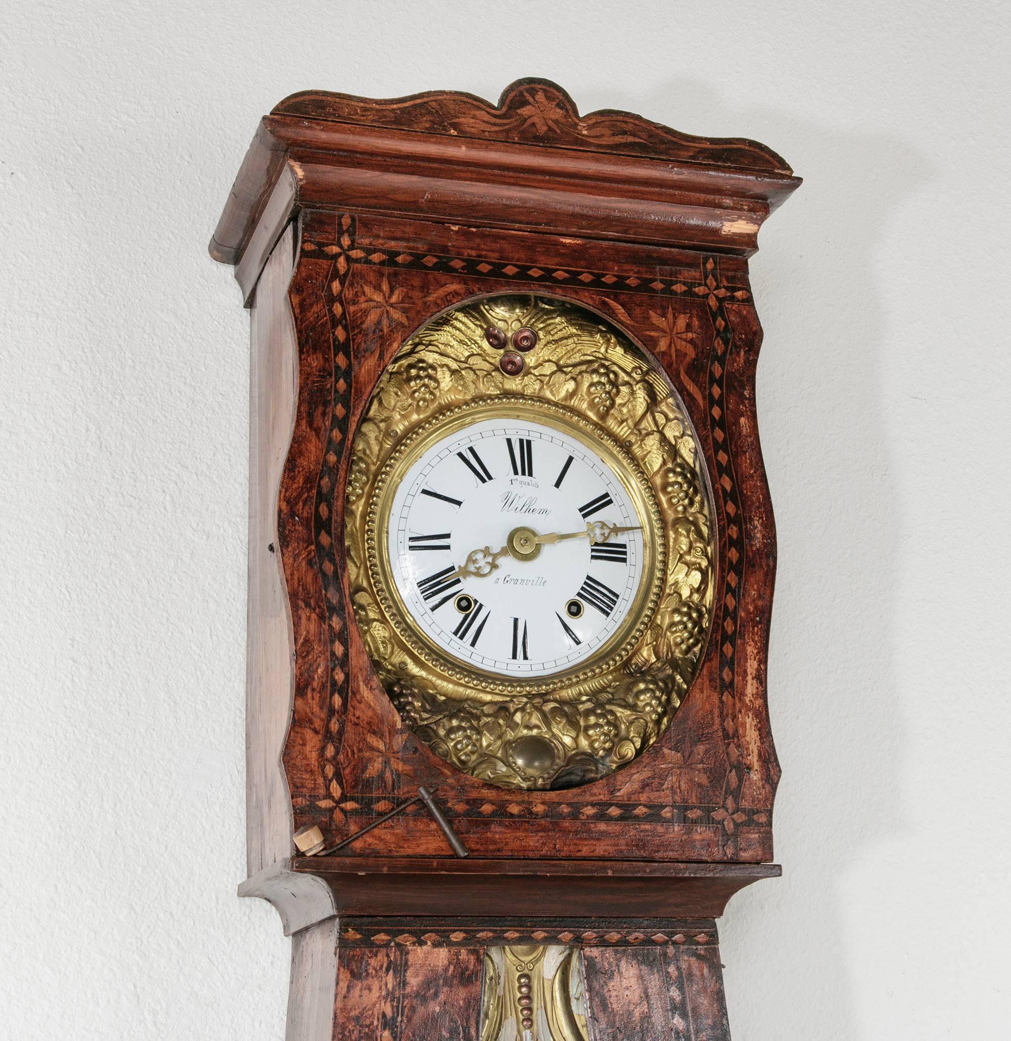 This circa 1850 grandfather clock is housed in a pine case elaborately painted in its original faux bois, as was the custom for these country clocks often found in the farmhouses in mid-19th century France. Its seven day Morbier clock movement