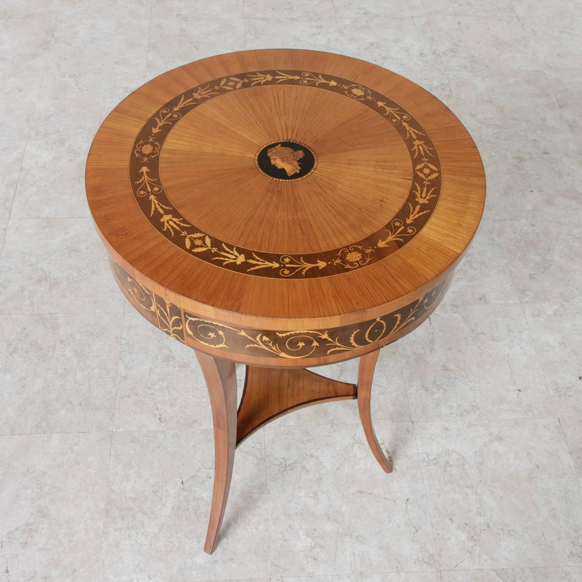 A stunning rare find! This Biedermeier period vanity table from Austria showcases a lemonwood marquetry top in a sunburst pattern. Its central ebony medallion features an inlaid Grecian profile of a classic female figure. A band of sycamore wood