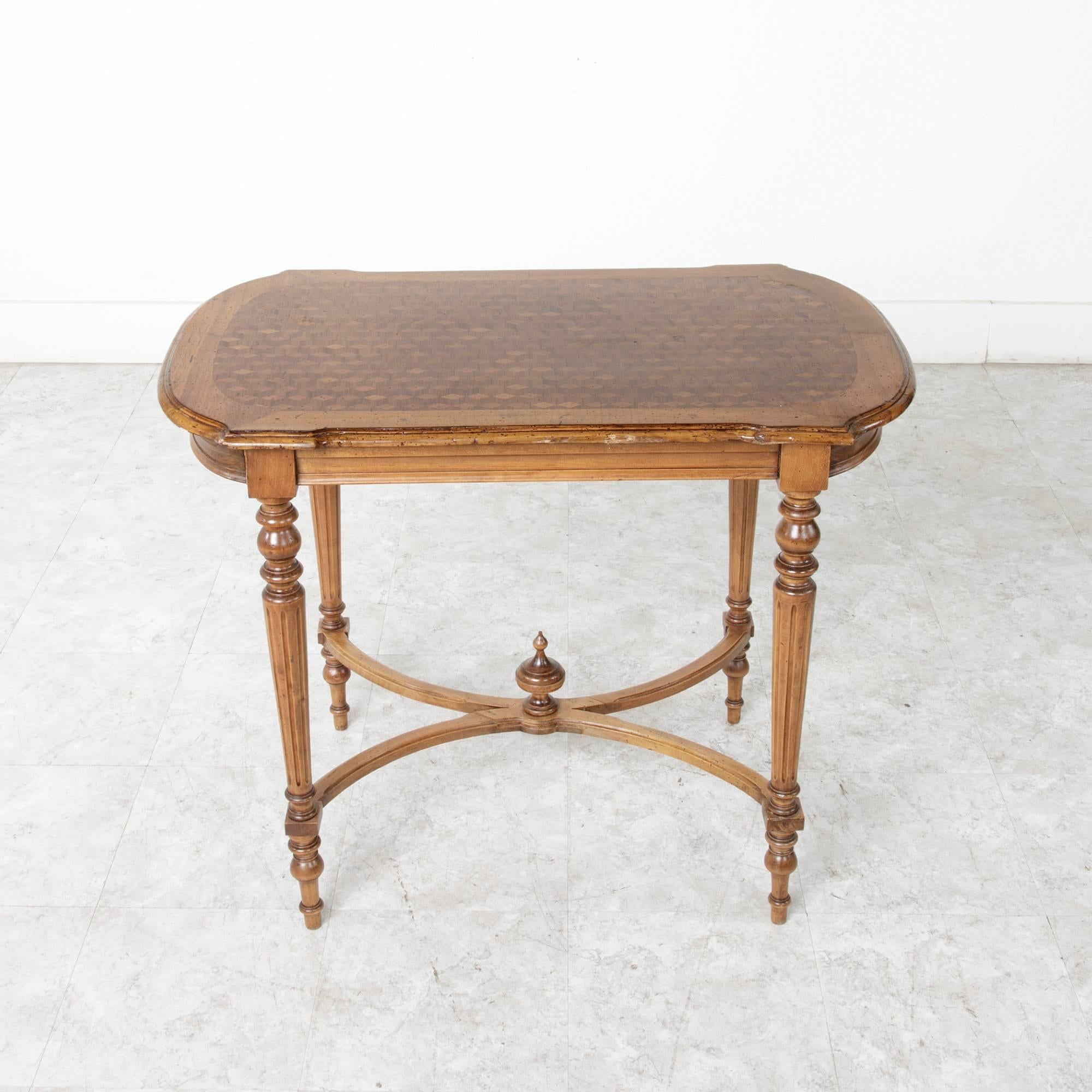 An elegant geometric diamond pattern created from inlaid blond mahogany gives the top of this writing desk great interest. Its simple beveled apron allows the mahogany wood grain to take prominence and leads to tapered, fluted legs with a lower