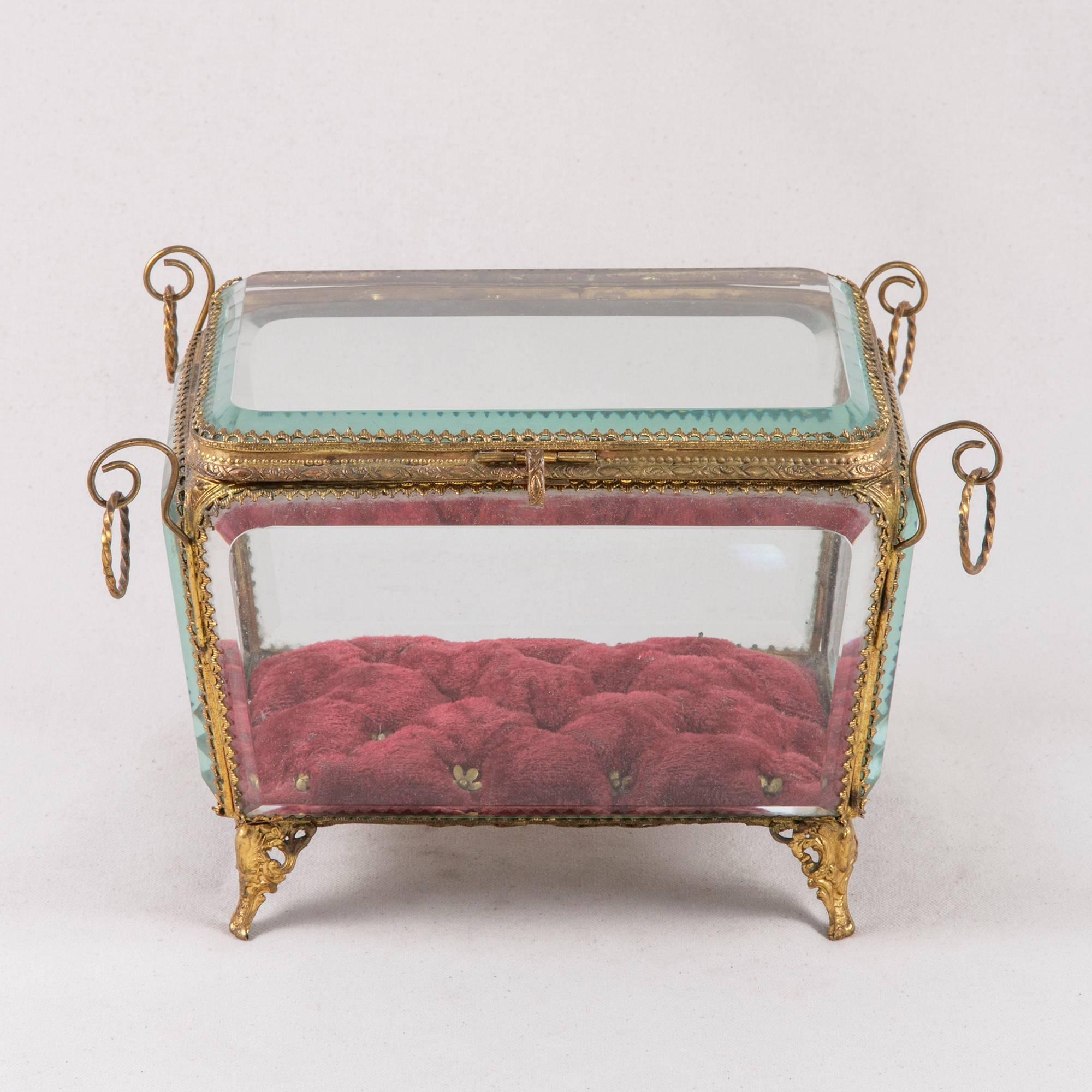 Your cherished keepsakes will find an elegant home in this French 19th century crystal jewelry box from the Napoleon III period. Featuring brass detailing and a red tufted velvet interior, the brass frame holds five beveled windows accented by