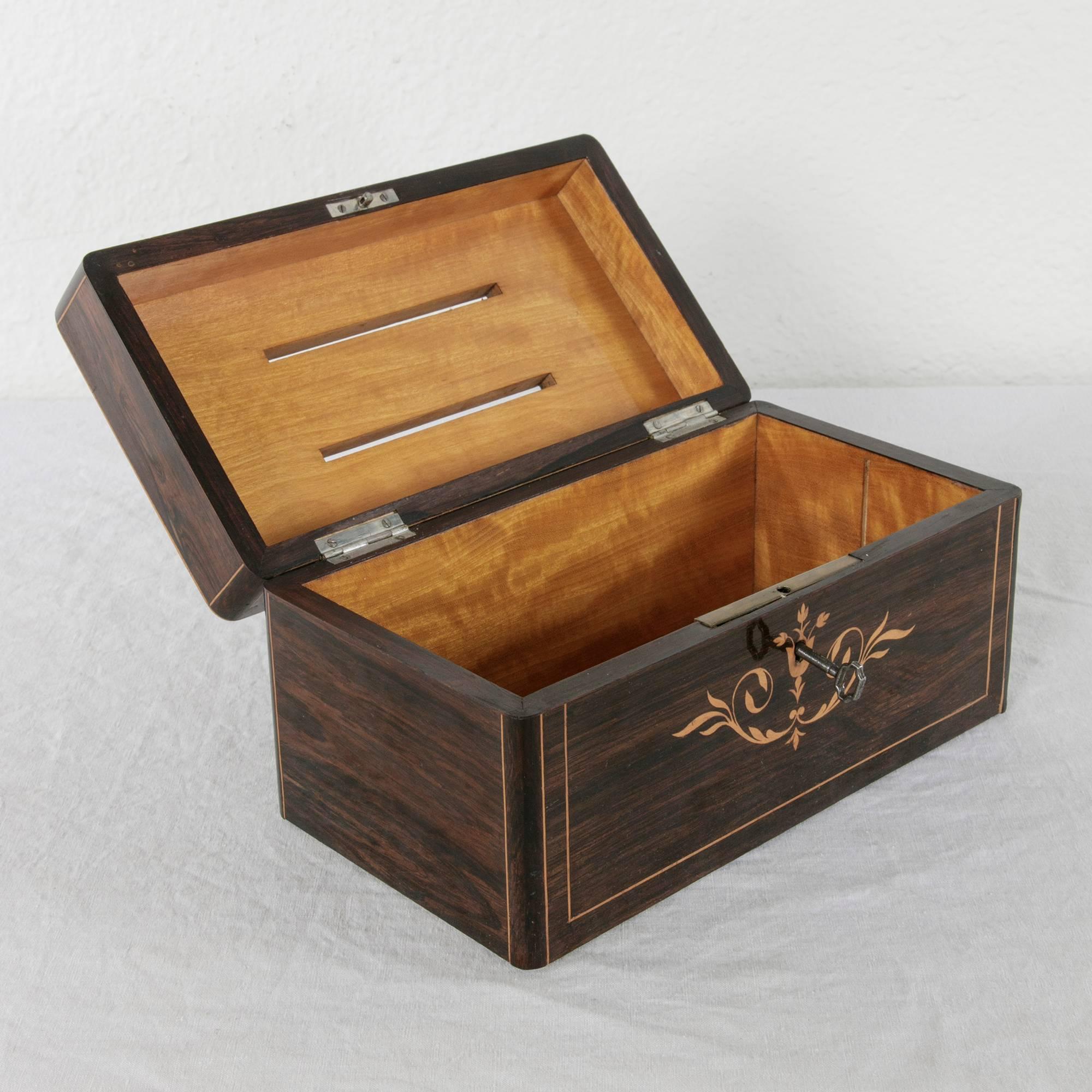 This beautifully inlaid Charles X period box is made from rosewood with lemonwood inlay detailing. The French word for letters, is elegantly inlaid with lemonwood into the top of the box. With two slots in the top originally used for letters