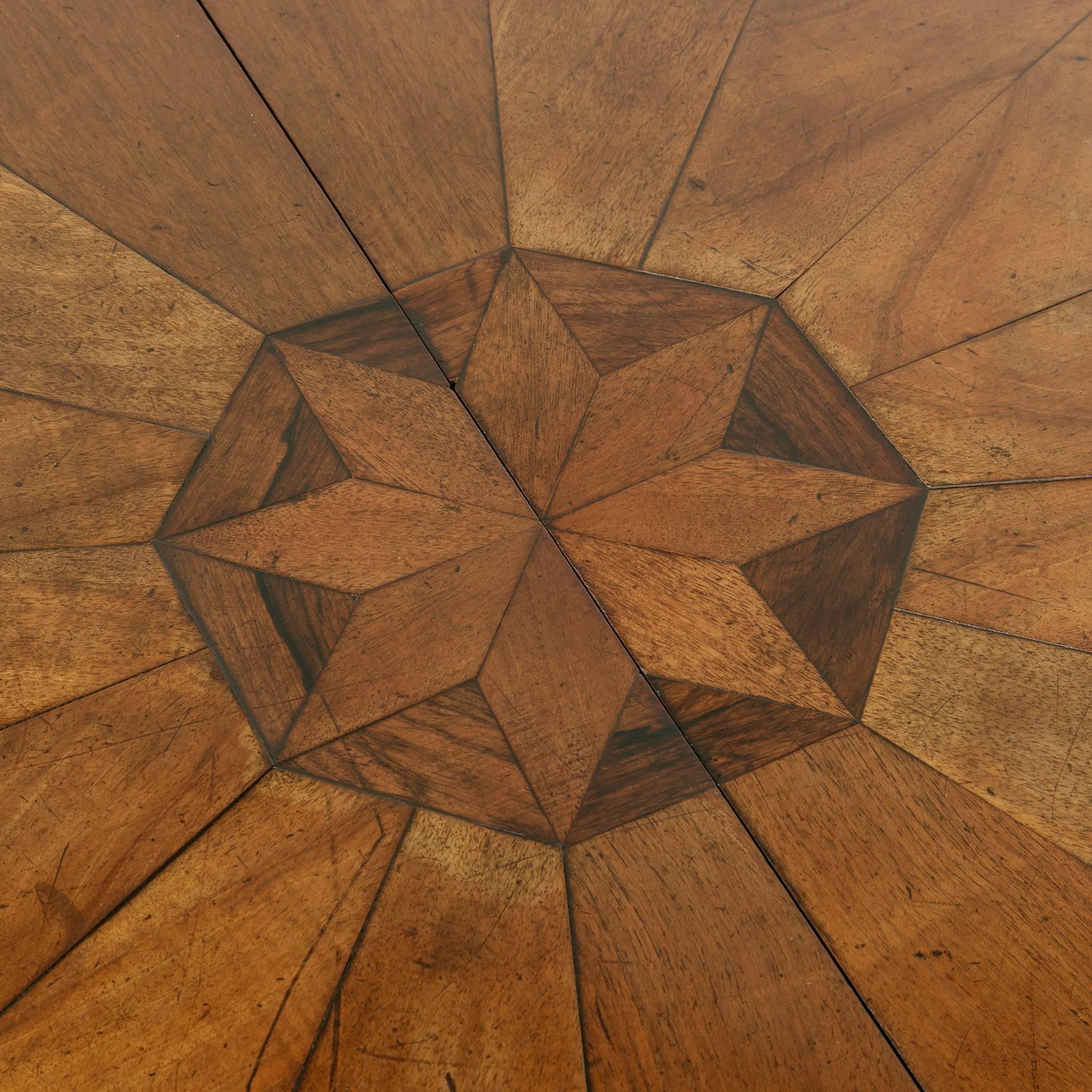 This Napoleon III period walnut gueridon or pedestal table is from the region of Alsace in eastern France. Its marquetry top is constructed of 16 walnut pieces that form a wheel around a central medallion of an eight pointed star inlaid in