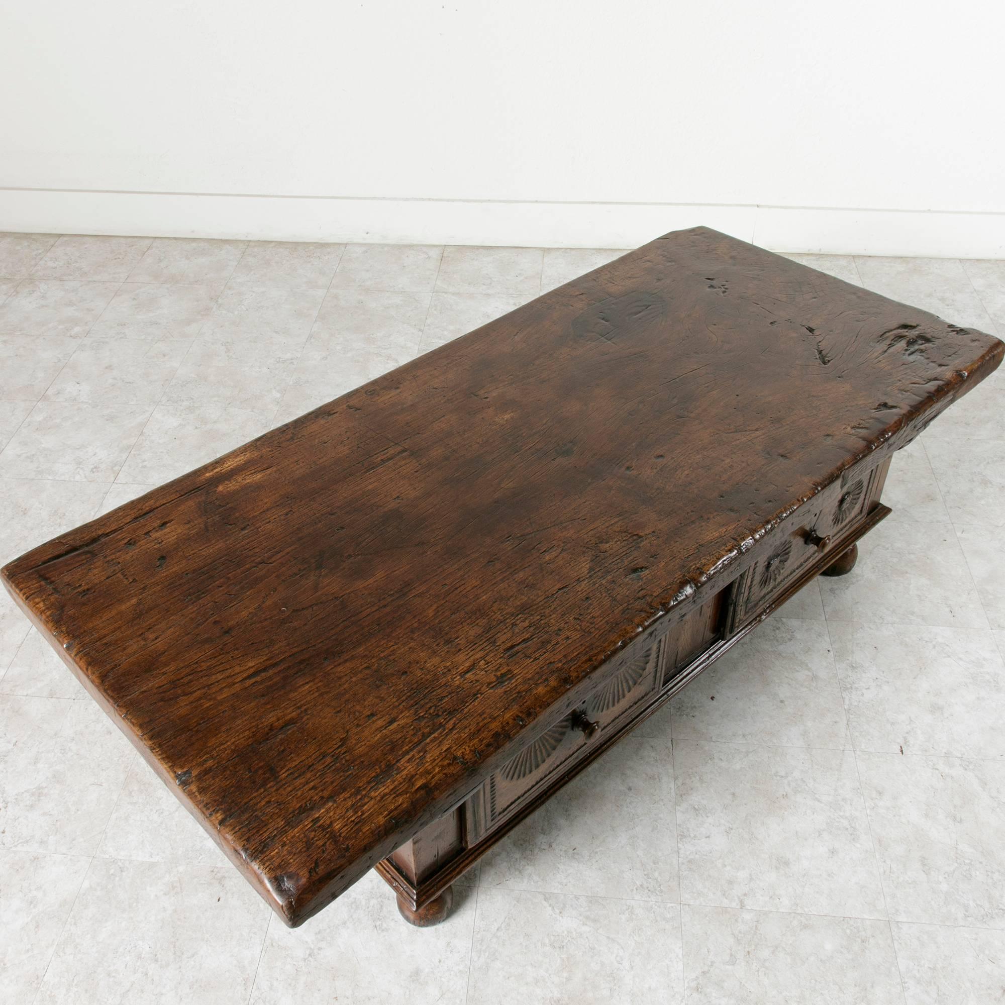 Recently found in a chateau in Normandy, France, near the city of Evreux, this eighteenth century coffee table boasts a solid 2.5 inch thick top made of a single piece of walnut. Two drawers of dovetail construction feature hand-carved fronts, each