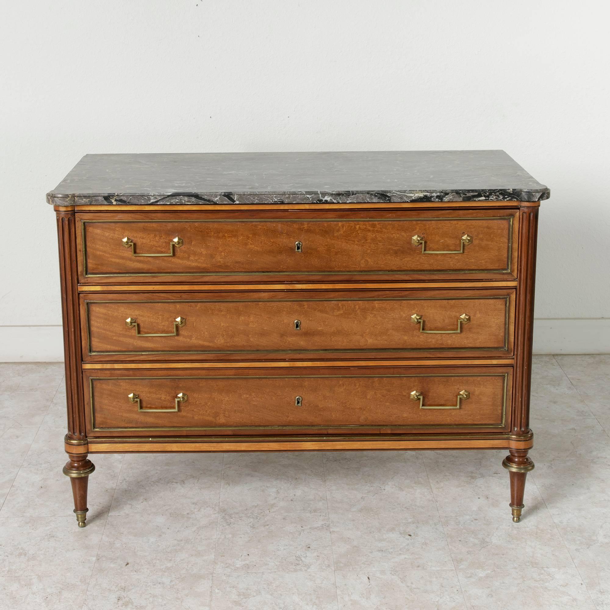 Ready to grace a room with its refined, straight lines, this rare Louis XVI period chest features very unusual inlay of Cuban mahogany, lemonwood, and ebony. A unique piece detailed with bronze banding and a turquin blue marble top, its fluted