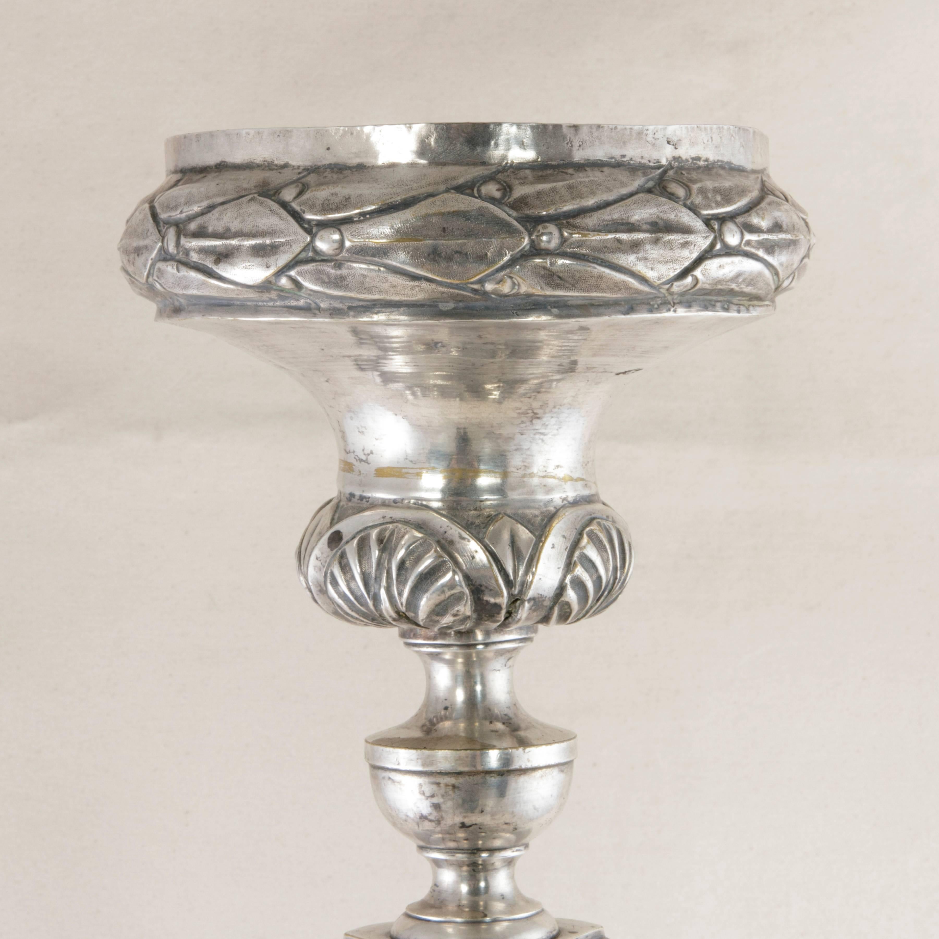 Originally used in a French chapel, this exquisite silver plate repousse pricket or candlestick from the late 19th century stands two and a half feet tall and features intricate detailing of acanthus leaves and laurels, as well as geometric designs,