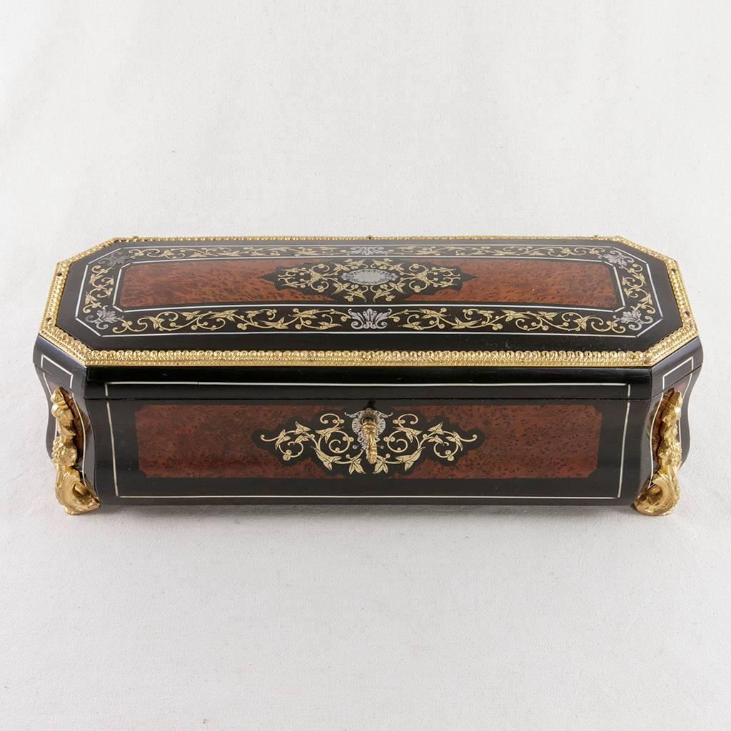 This exceptional Napoleon III period glove box is made of tuya, an exotic wood imported to France from North Africa in the 19th century. It is accented with ebonized wood and exquisitely inlaid with bronze, silver, and bone. The intricate inlay work