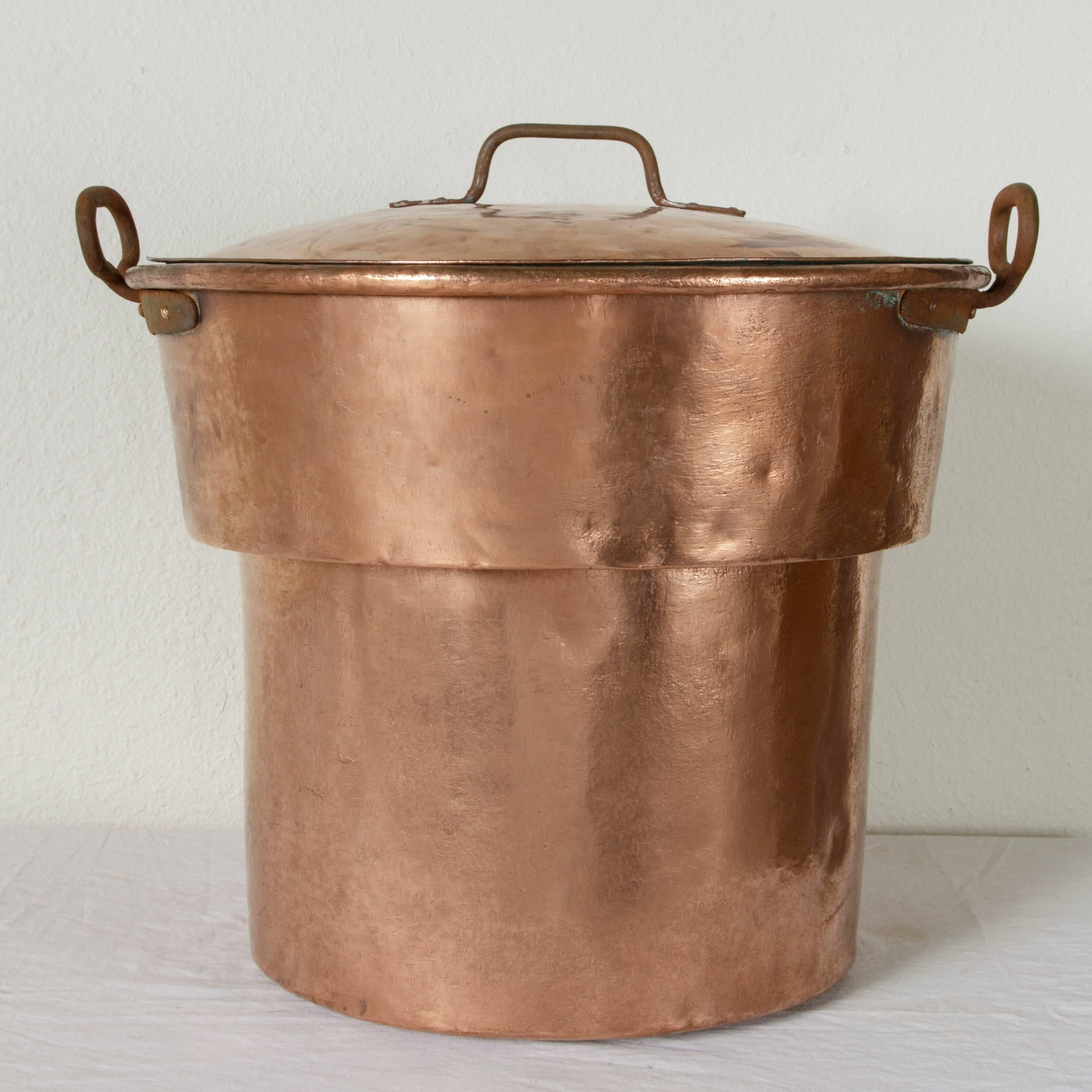 From the Cantal region of France, this very large nineteenth century copper stock pot with lid was originally used for heating milk in the cheese making process. Iron handles on the sides of the pot and on the lid allow for it to be carried with