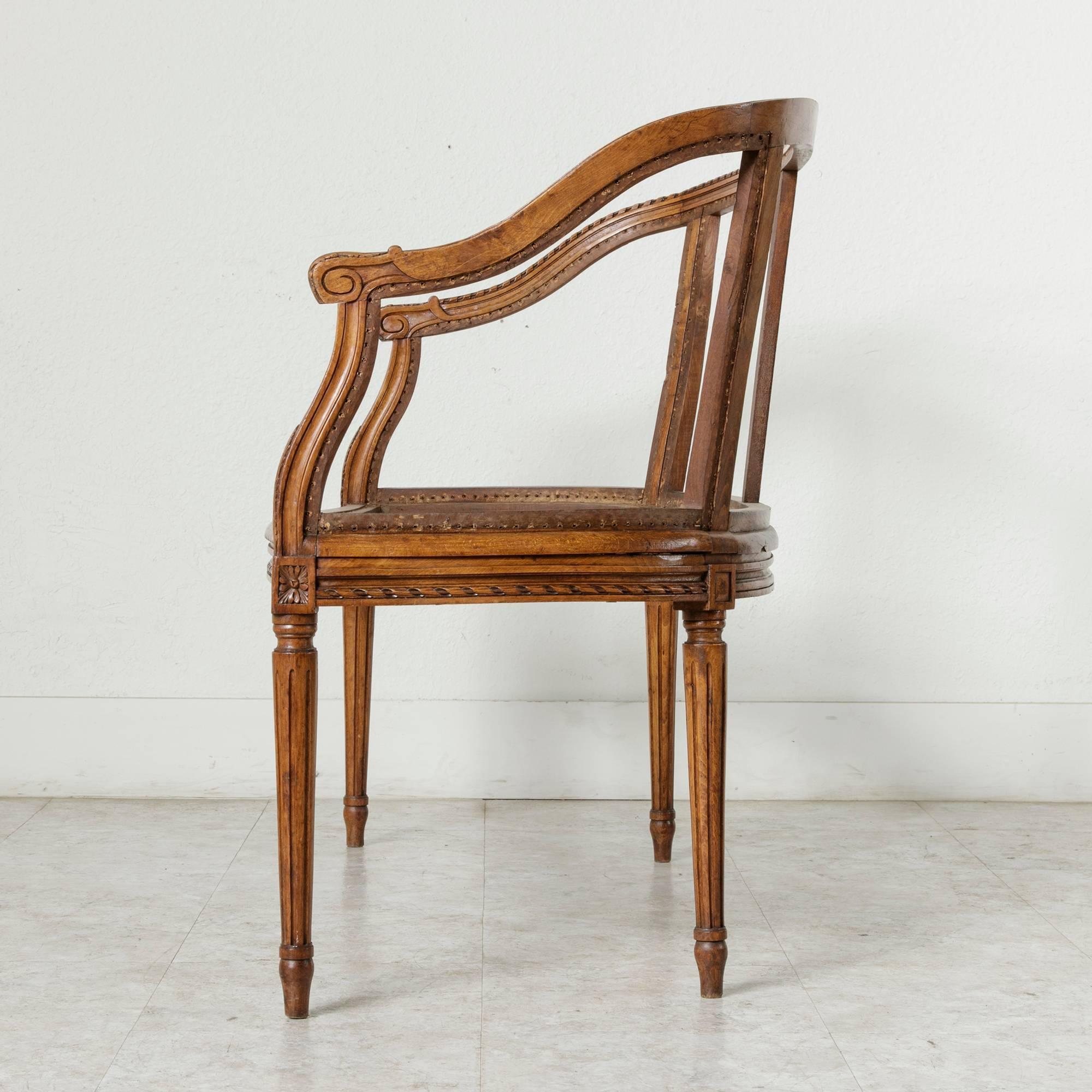 This hand-carved walnut banquette or bench from the late 19th century features Classic Louis XVI motifs. Carvings of twisted ribbon run along the front and sides of the seat and are repeated along the seat back of the bench. 
 Rosettes adorn the