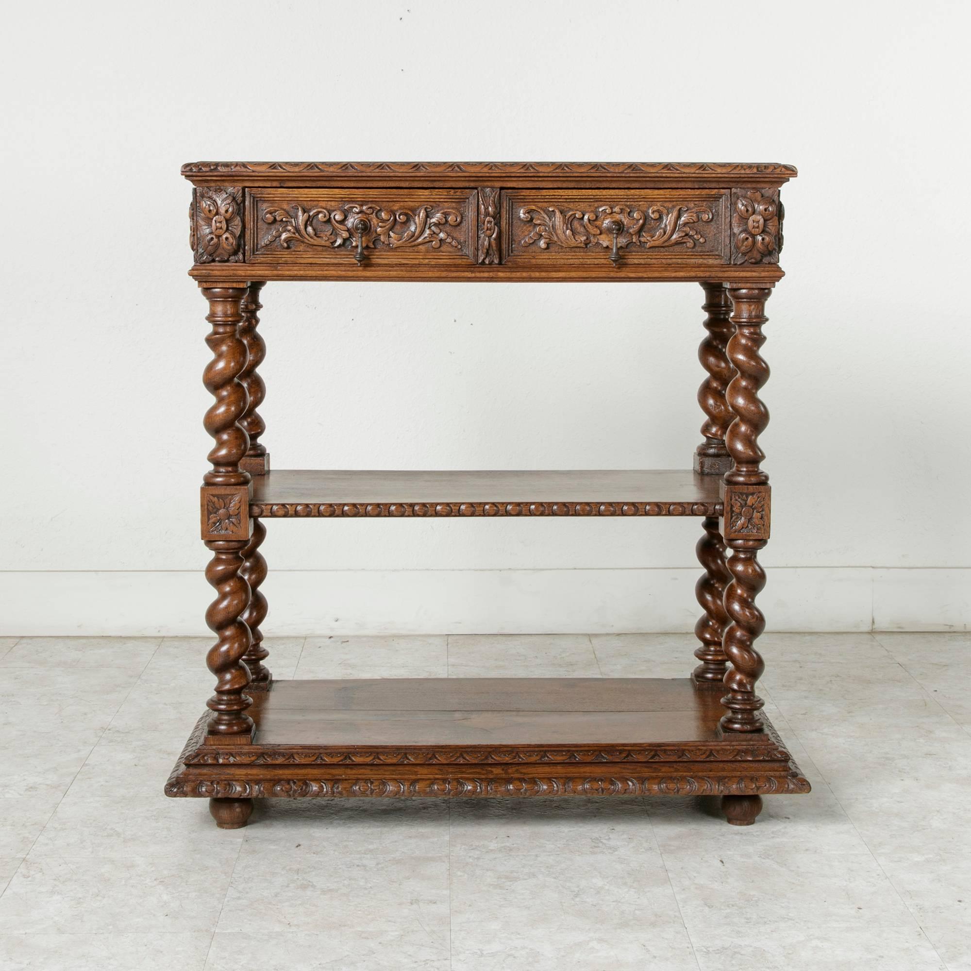 This hand-carved oak Louis XIII style dessert buffet from the late nineteenth century features carvings on three sides. Rosettes adorn the die joints, and cartouches flanked by acanthus leaves embellish the sides and drawer fronts. A shell and leaf