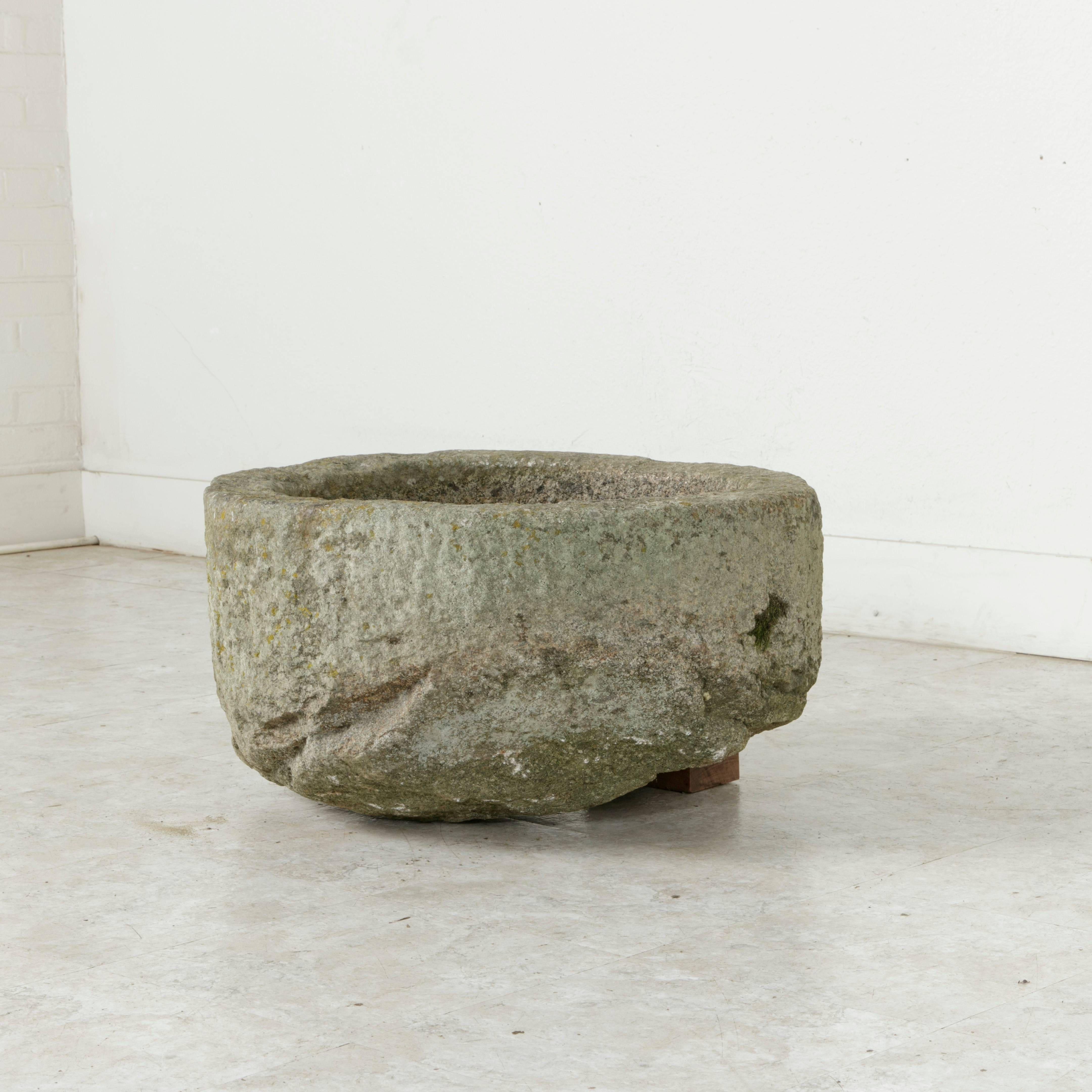 Found in Normandy, France, this hand-cut stone auge, or trough from the 19th century was originally used to feed or water farm animals. Rare for its round shape and seven inch deep basin, this piece would be ideal as a planter, fountain basin, or a