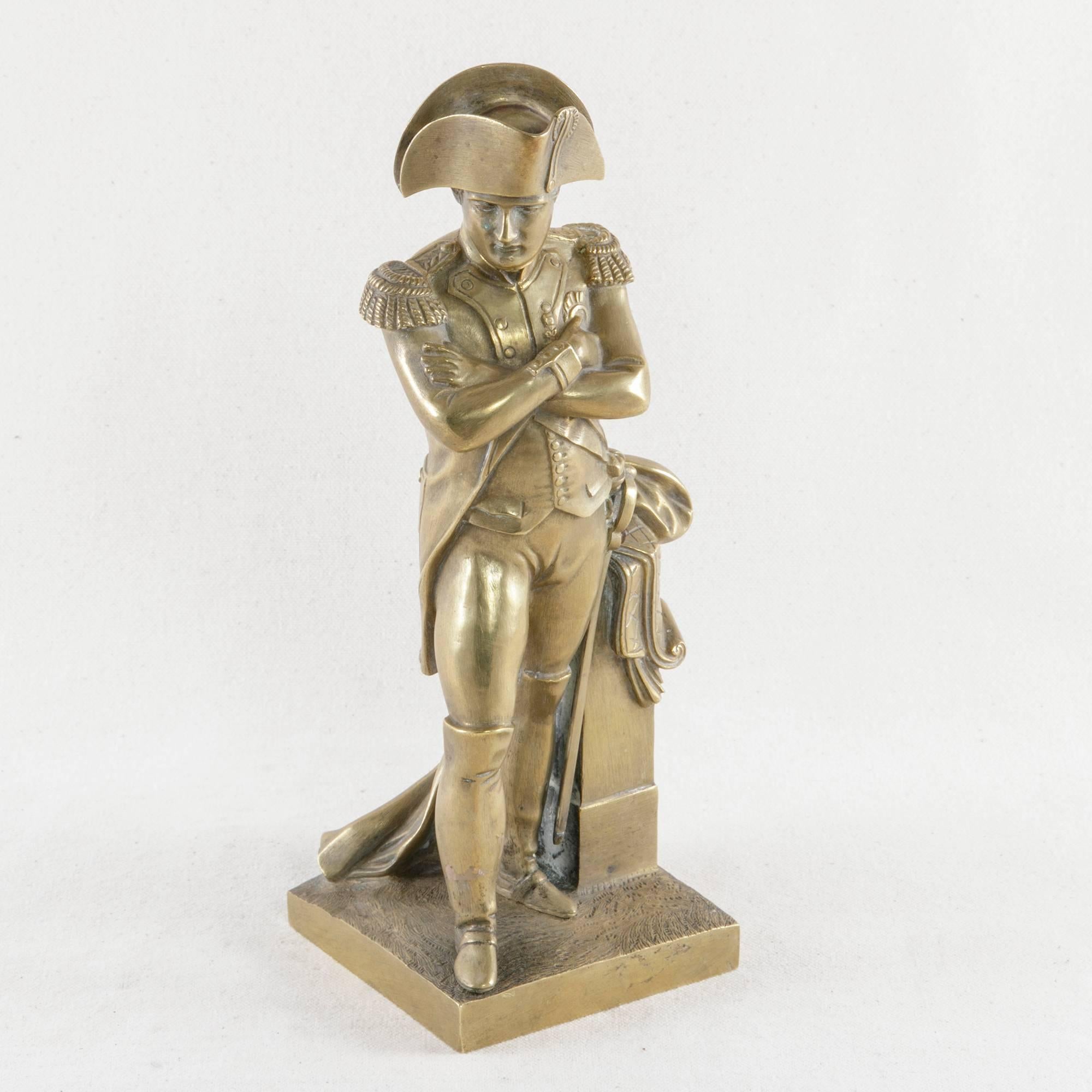 Standing authoritatively in Classic military dress with arms crossed, this solid bronze statue of Napoleon Bonaparte presents the French emperor masterfully posed beside a half-column. Often representing a golden age in French history, Napoleon was