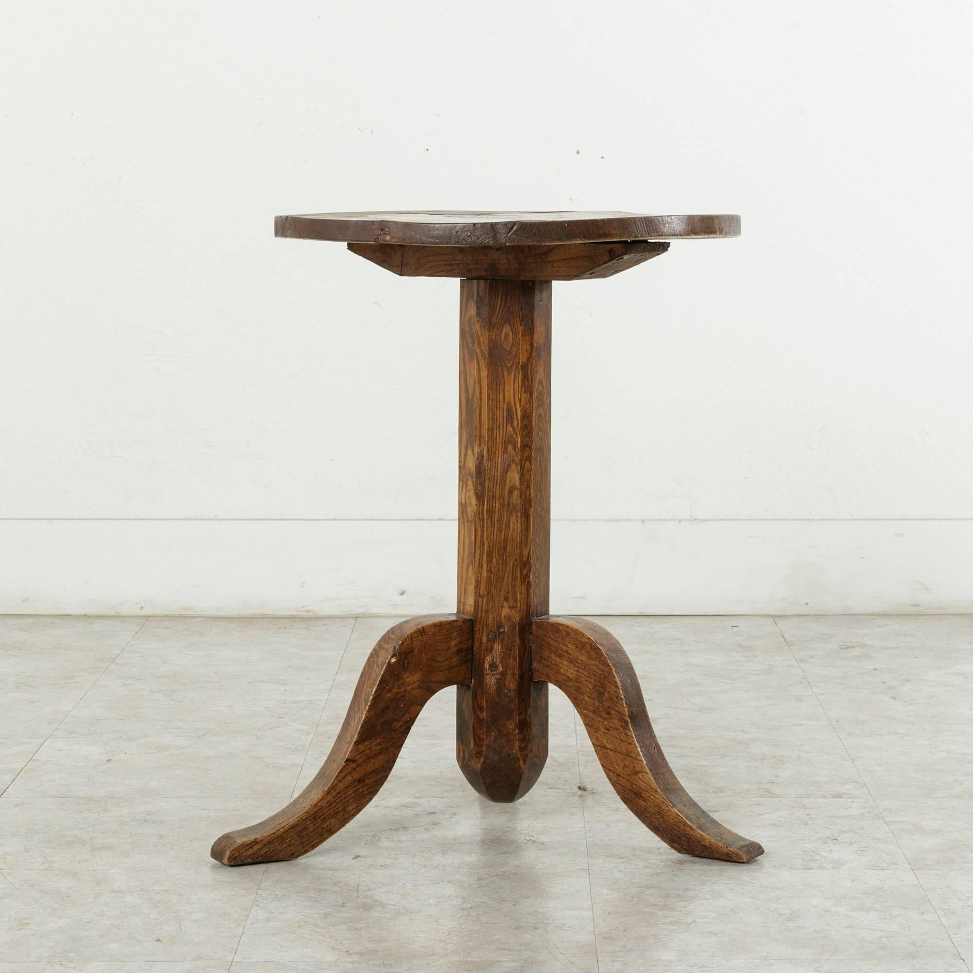 Crafted in Normandy, France, for a French farmhouse, this 19th century artisan-made side table is constructed of chestnut. Its stout, hand pegged tripod base and hand hewn top lend stability and durability as well as rustic charm. Its 24 inch height