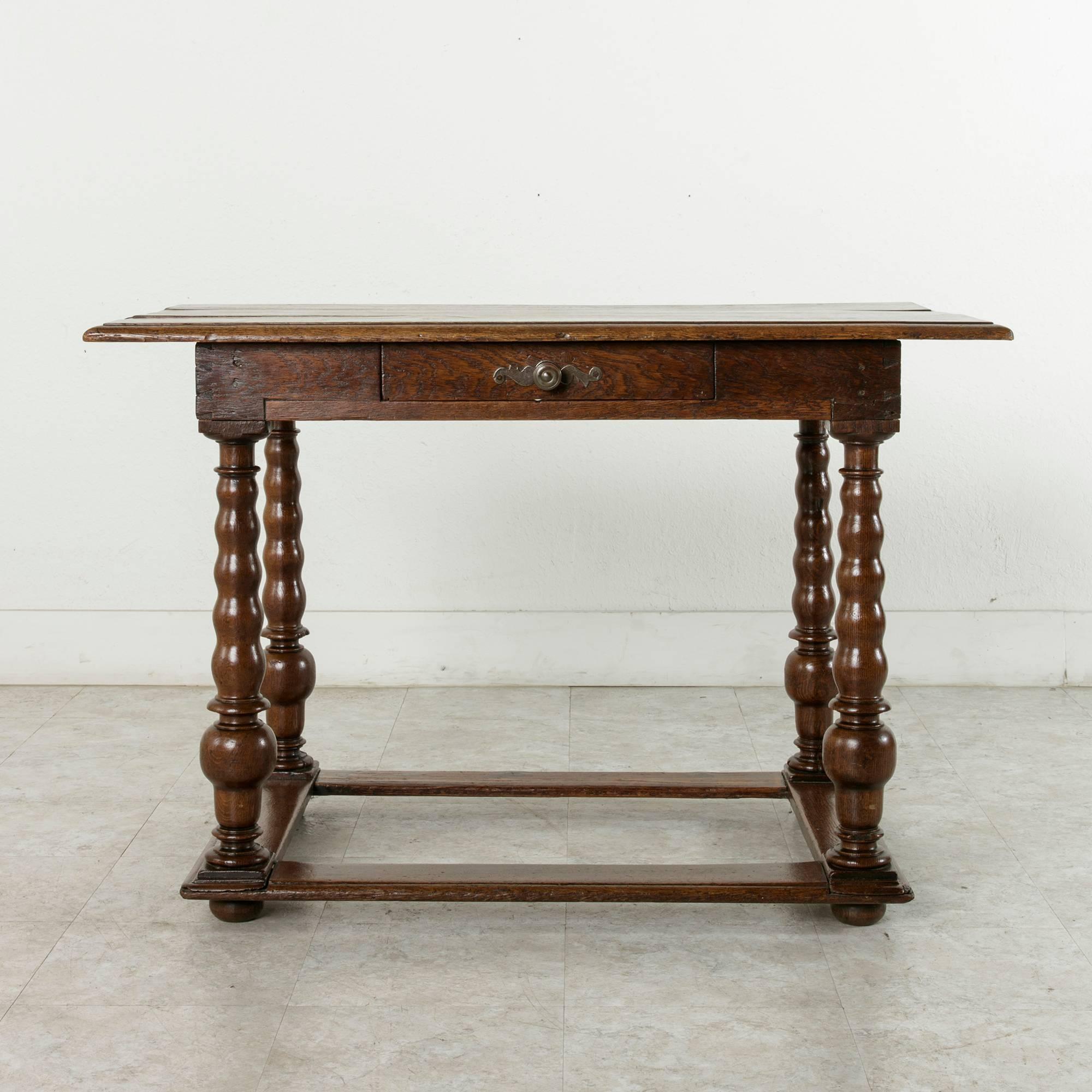 This Louis XIII period French oak table from the 17th century is of dovetailed and hand-pegged construction. Its beveled top formed from three planks of wood rests over a single drawer with hand-cut dovetails at both the front and back of the