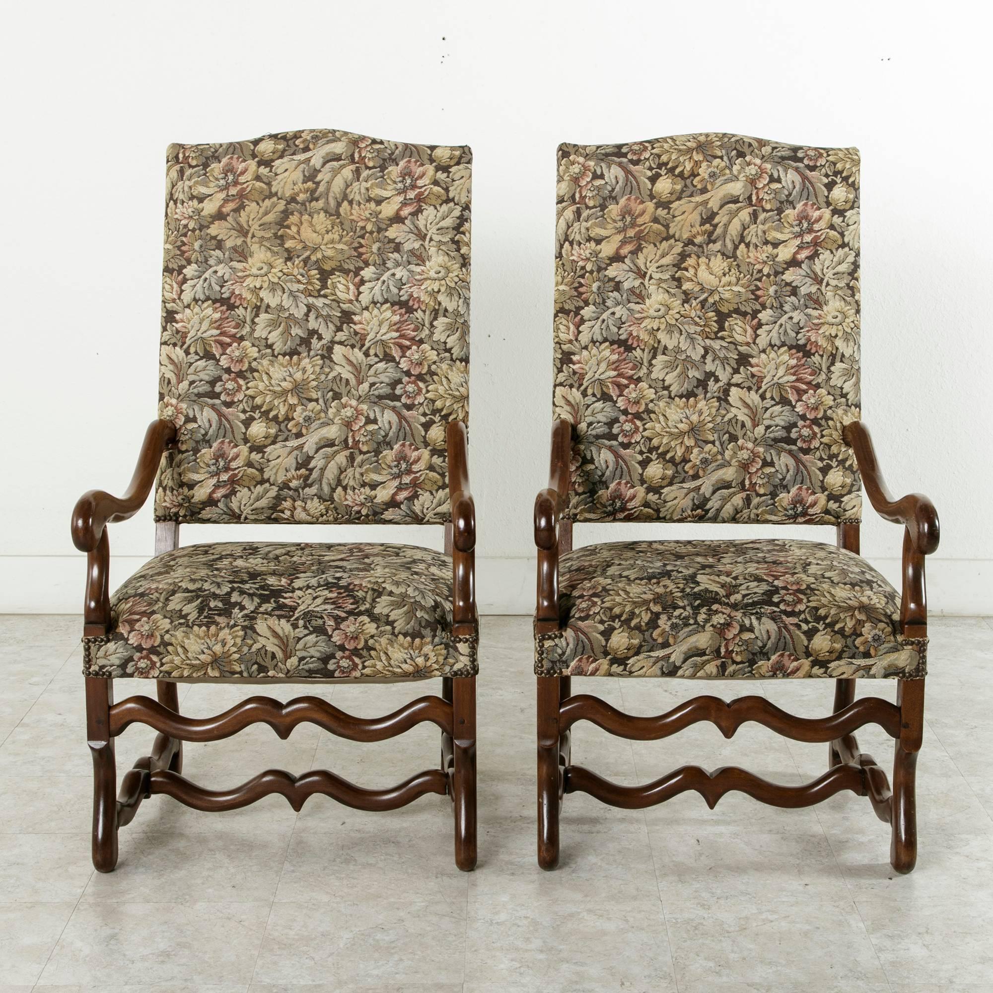 This handsome pair of hand pegged walnut Louis XIV style mutton leg armchairs is classic in style. The slight incline of the back and ample seat width make them extremely comfortable. The upholstery finished with a nail head trim is in good