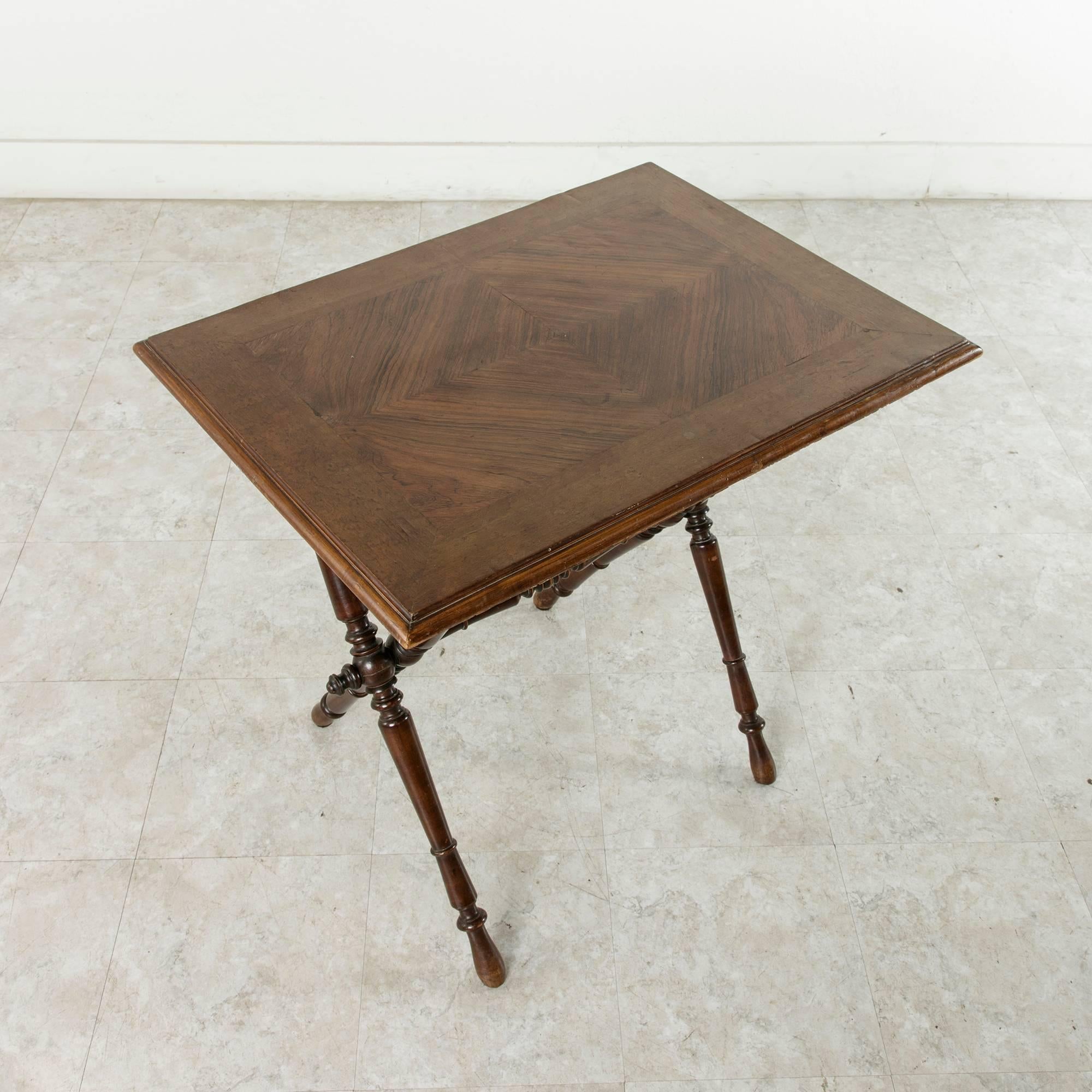 This 19th century French Campaign table features a top made of a central inlay of bookmatched palisander surrounded by plum pudding mahogany. Created in 1870 in the style of a military Campaign table, the top slides forward and the table folds flat