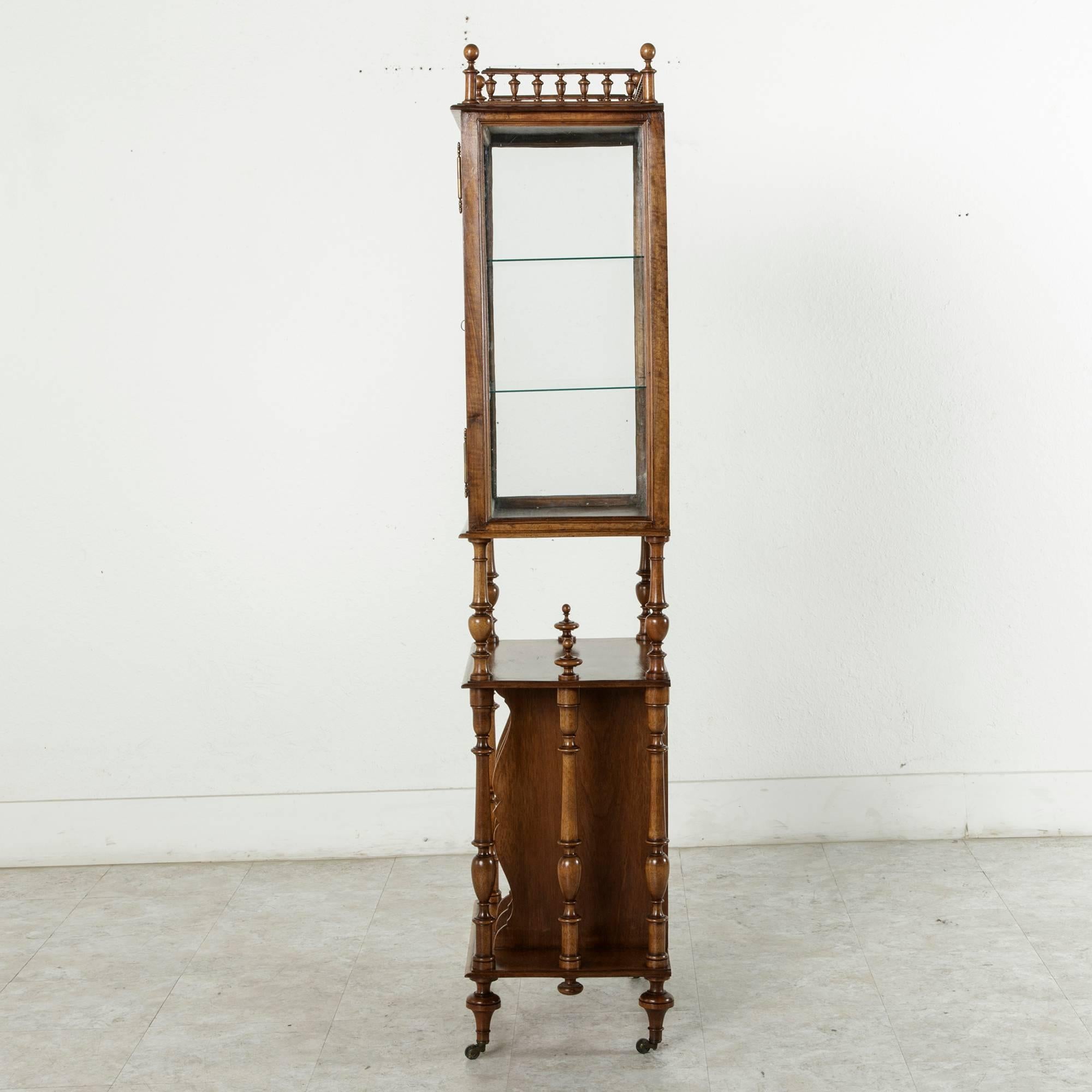 This late 19th century French walnut vitrine was originally used as a music cabinet. Its upper cabinet has a mirror at the back, glass on three sides, and two glass shelves, ideal for displaying a collection of objets d'arts that can be viewed on