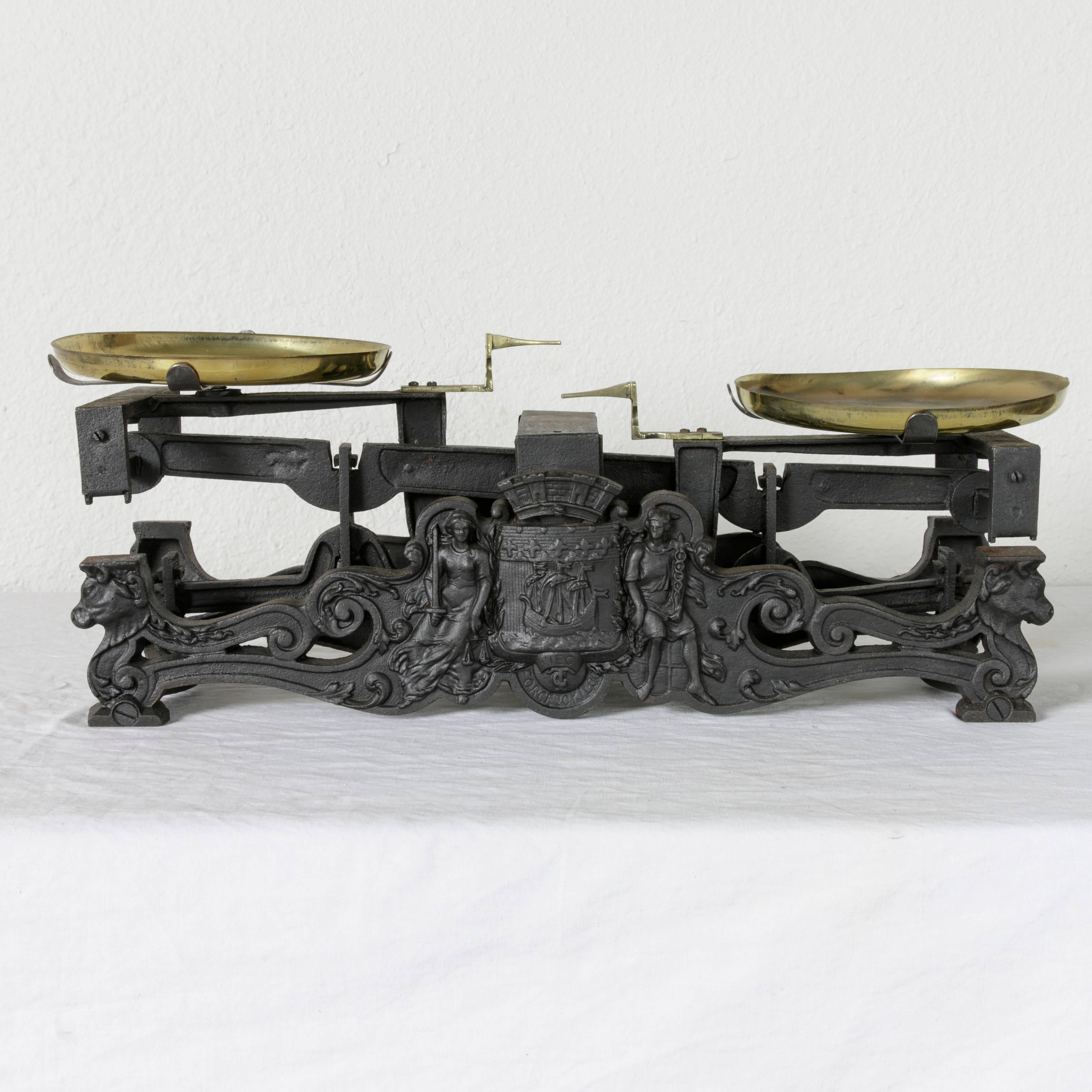This set of late nineteenth century French iron baker's scales is double faced and features the coat of arms of the city of Paris flanked by the messenger god Mercury and Lady Justice. Under the coat of arms is marked Force 20 Kilos, indicating the