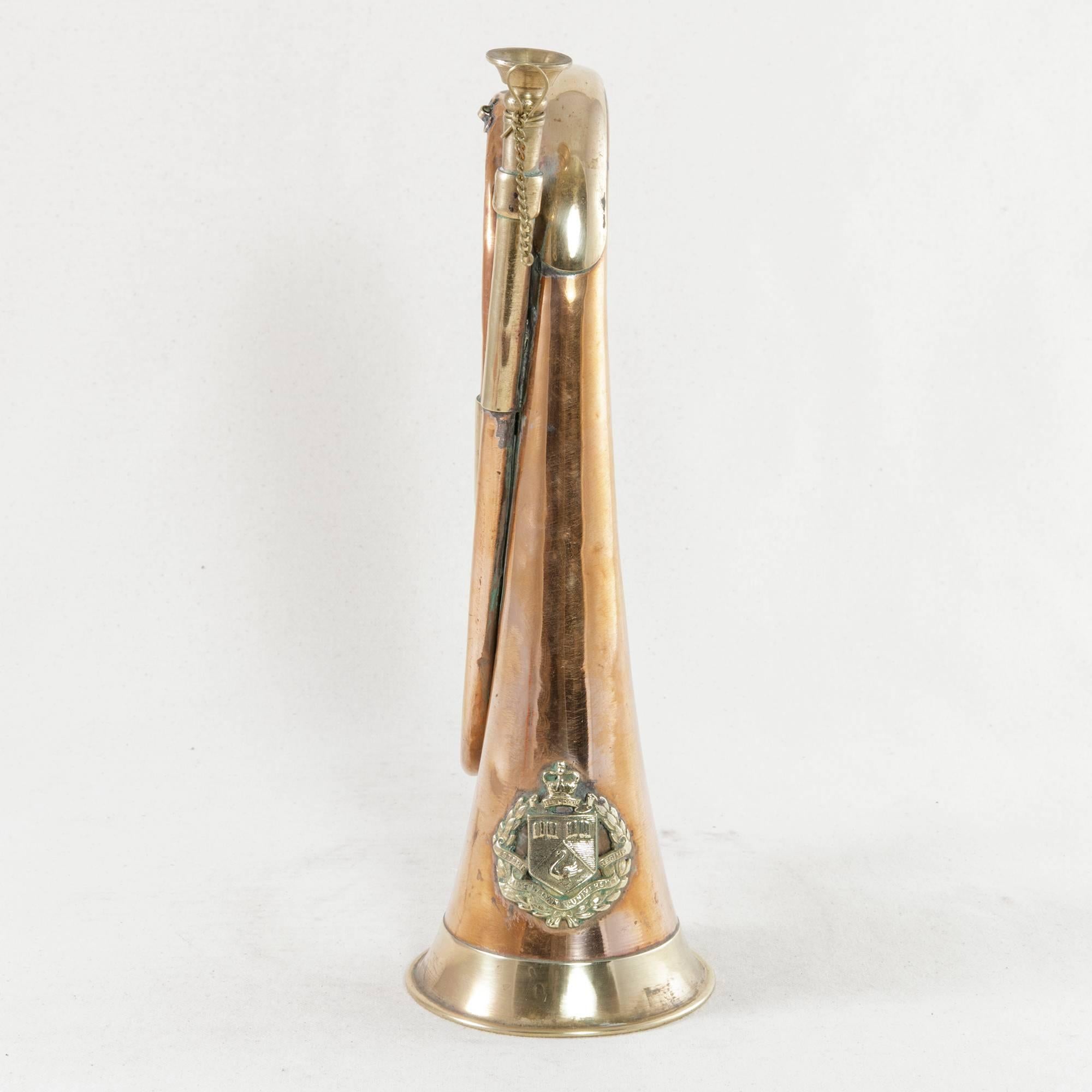 This midcentury copper and brass bugle features the bronze insignia for the Western Australian University Regiment with a swan and two open books. Laurels surround the central shield of the insignia with the regiment's motto Seek Wisdom and a crown