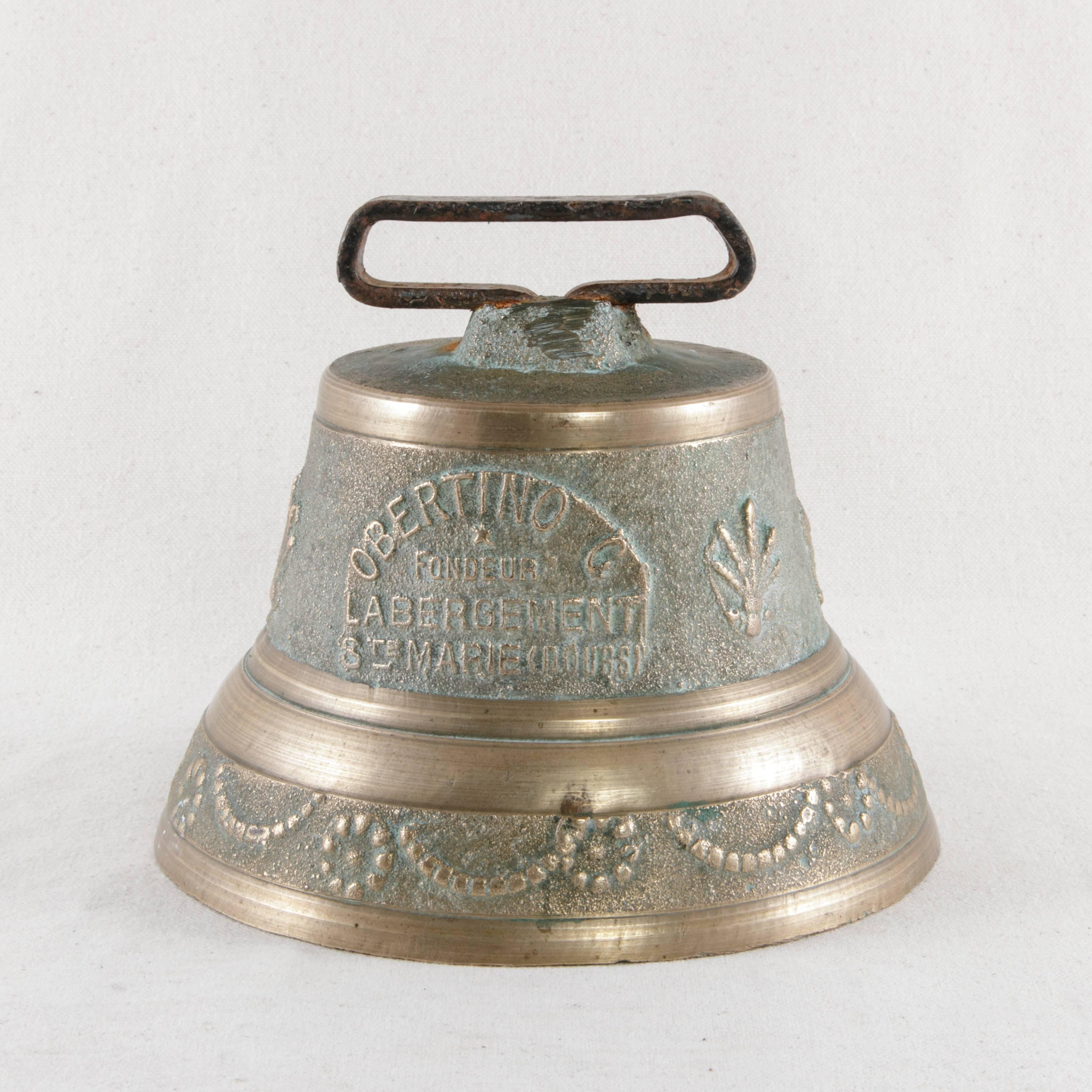 This 19th century cast bronze cow bell from the Jura mountains in eastern France is marked by the name of the foundry Obertino C. Fondeur L'abergement Saint Marie (Doubs) established in the village of Doubs in 1834. Decorated with religious symbols,
