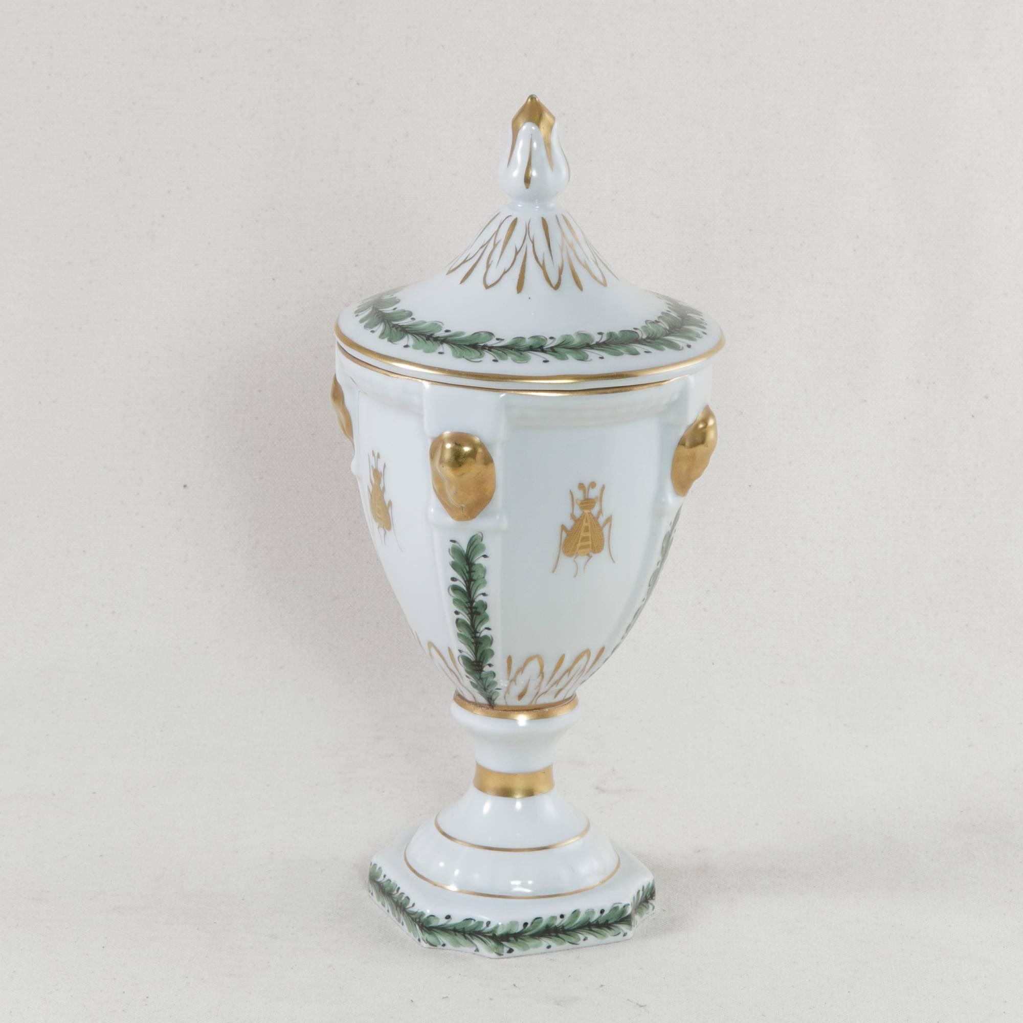 This 19th century French porcelain urn with lid features hand-painted Napoleonic motifs, notably the Napoleonic bee, a symbol chosen by the French emperor himself to signify unity, immortality, and resurrection. Further detailing of gold lines and