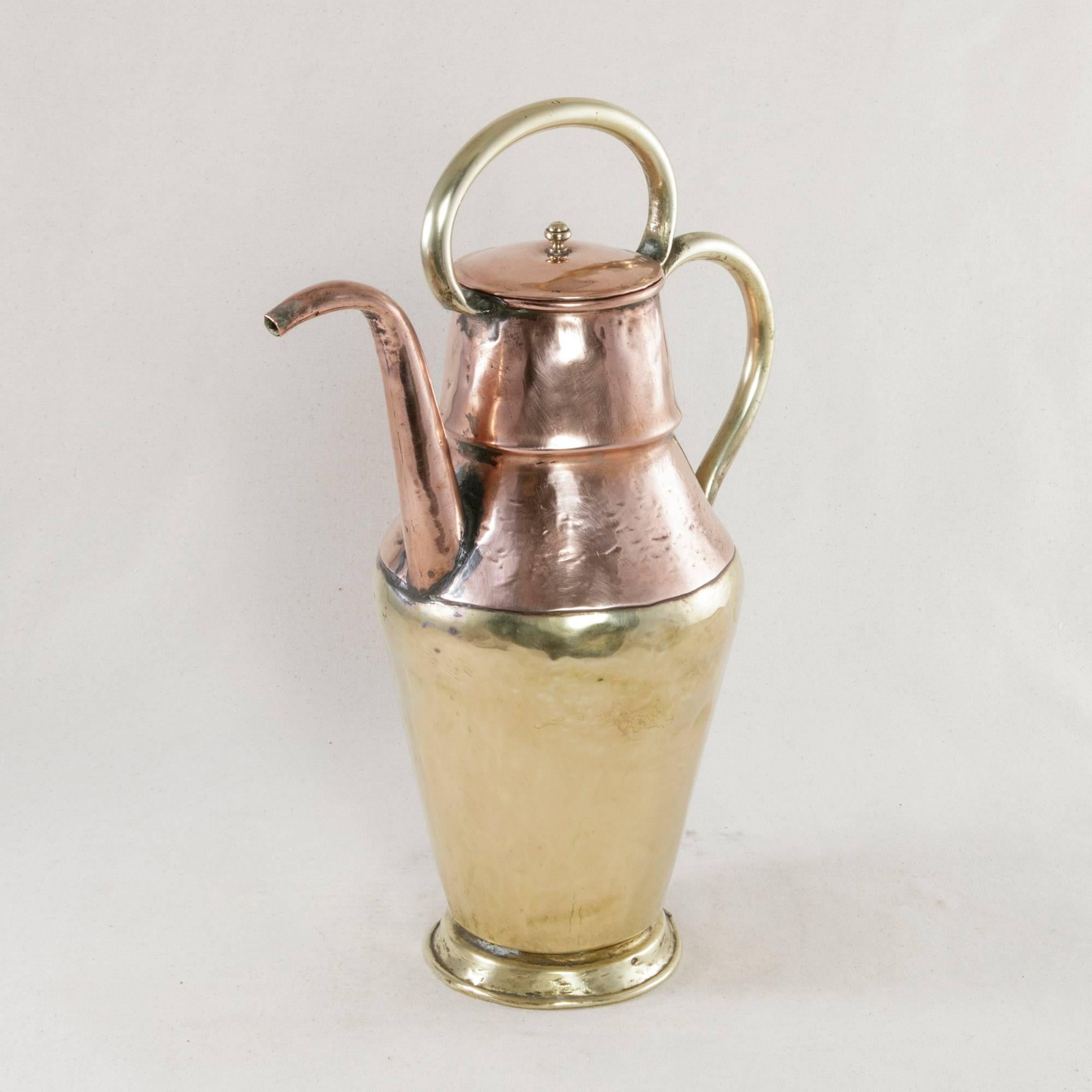 Taking the form of a Moorish teapot, this 19th century French piece features a stunning mixture of copper and brass. Its hand-hammered upper half has a copper spout and lid and two graceful brass handles. Evidence of its age is in the visible seam