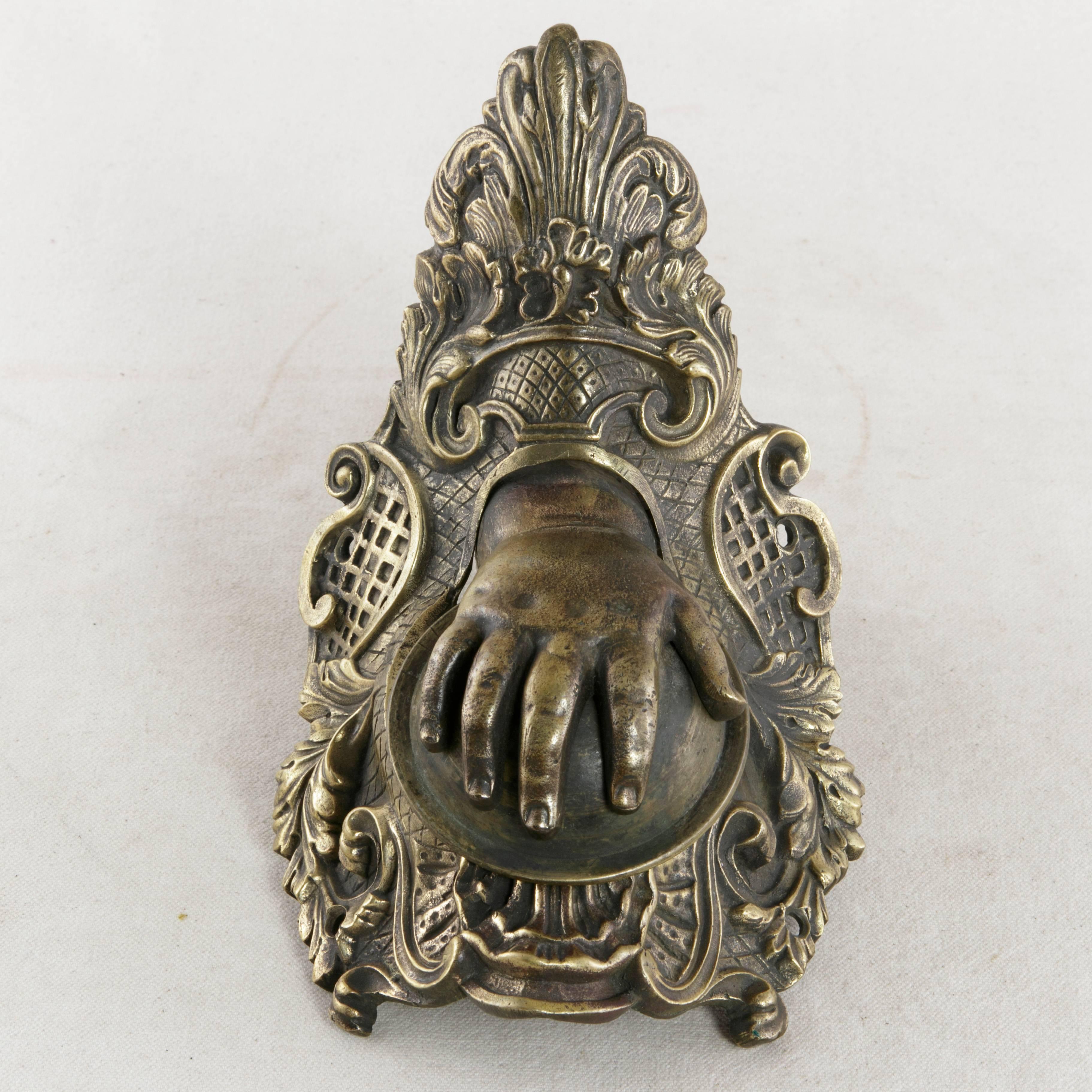 This 19th century Napoleon III period solid bronze billiard corner pocket features a dimpled child's hand. As a corner pocket on its original billiard table of the 1860s, the hand dropped forward when the billiard ball rolled into the pocket.