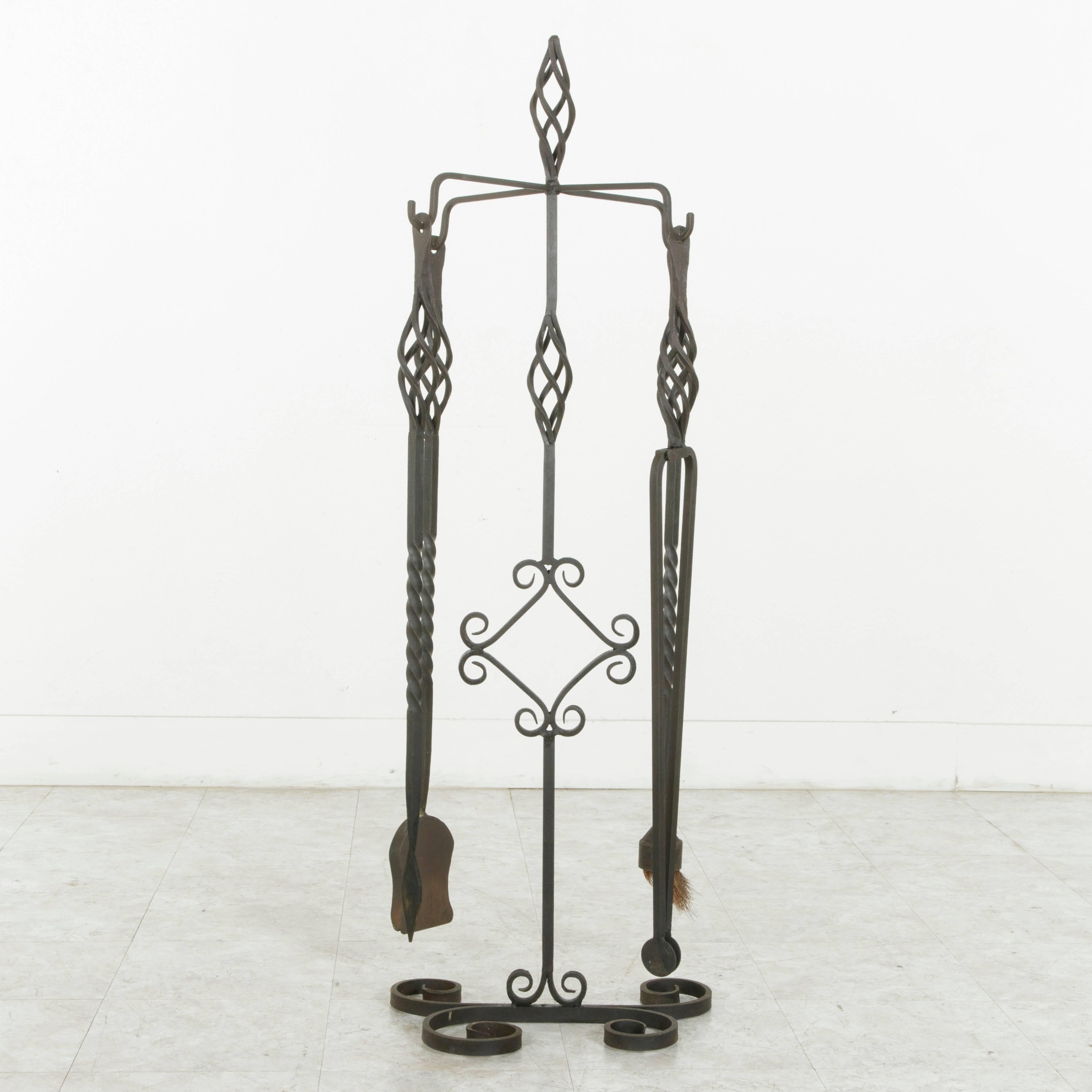 This artisan-made set of large hand forged iron fireplace tools was originally used at the massive stone fireplace of a French castle in Normandy, France.  Standing at an impressive height of 51 inches, the four tools include a poker, shovel, tongs,