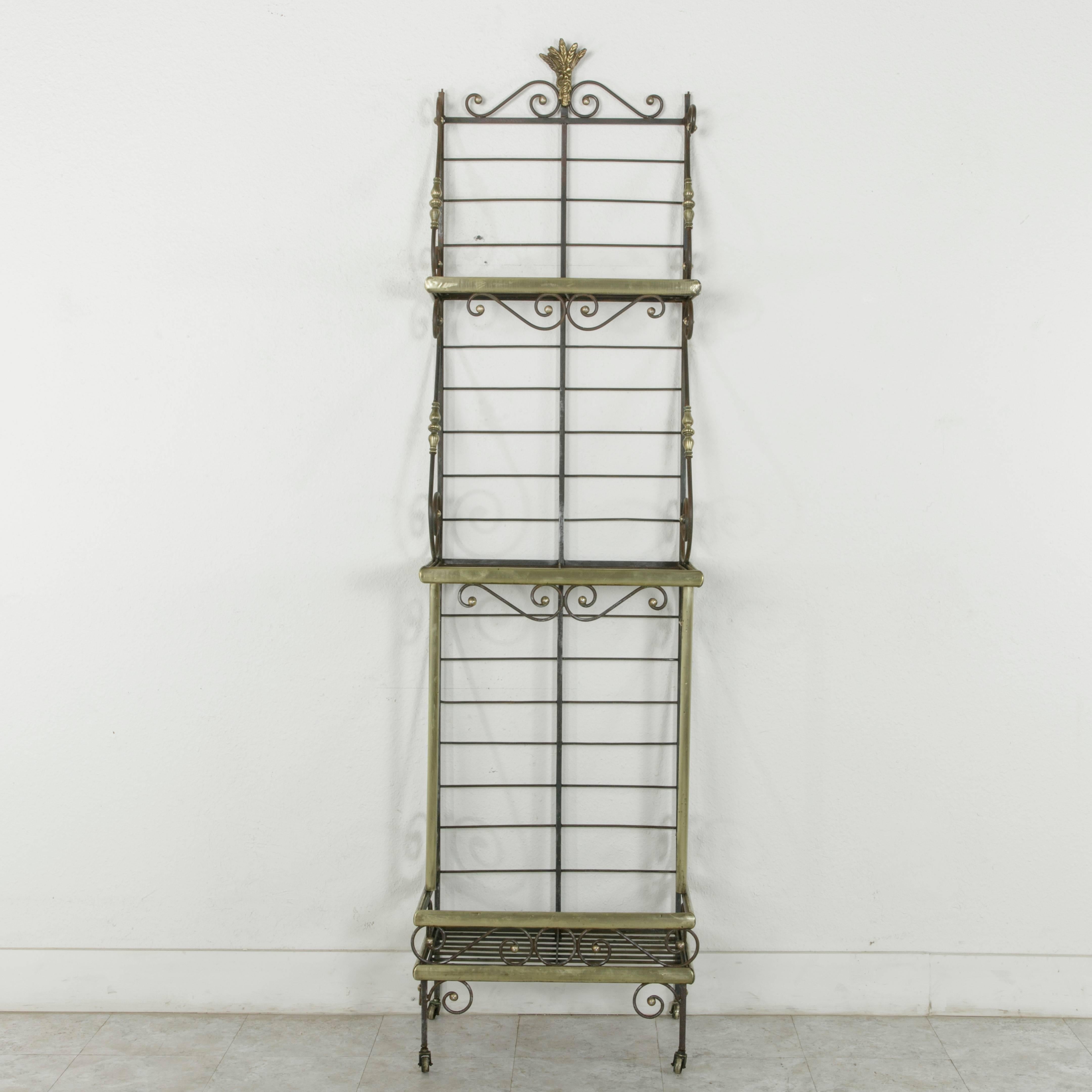 A rare find in a unique small scale, this French iron baker's rack from Normandy is trimmed in brass around each of its three shelves. The shelves are joined by scrolling iron detailed with brass turnings that lend support as well as an aesthetic