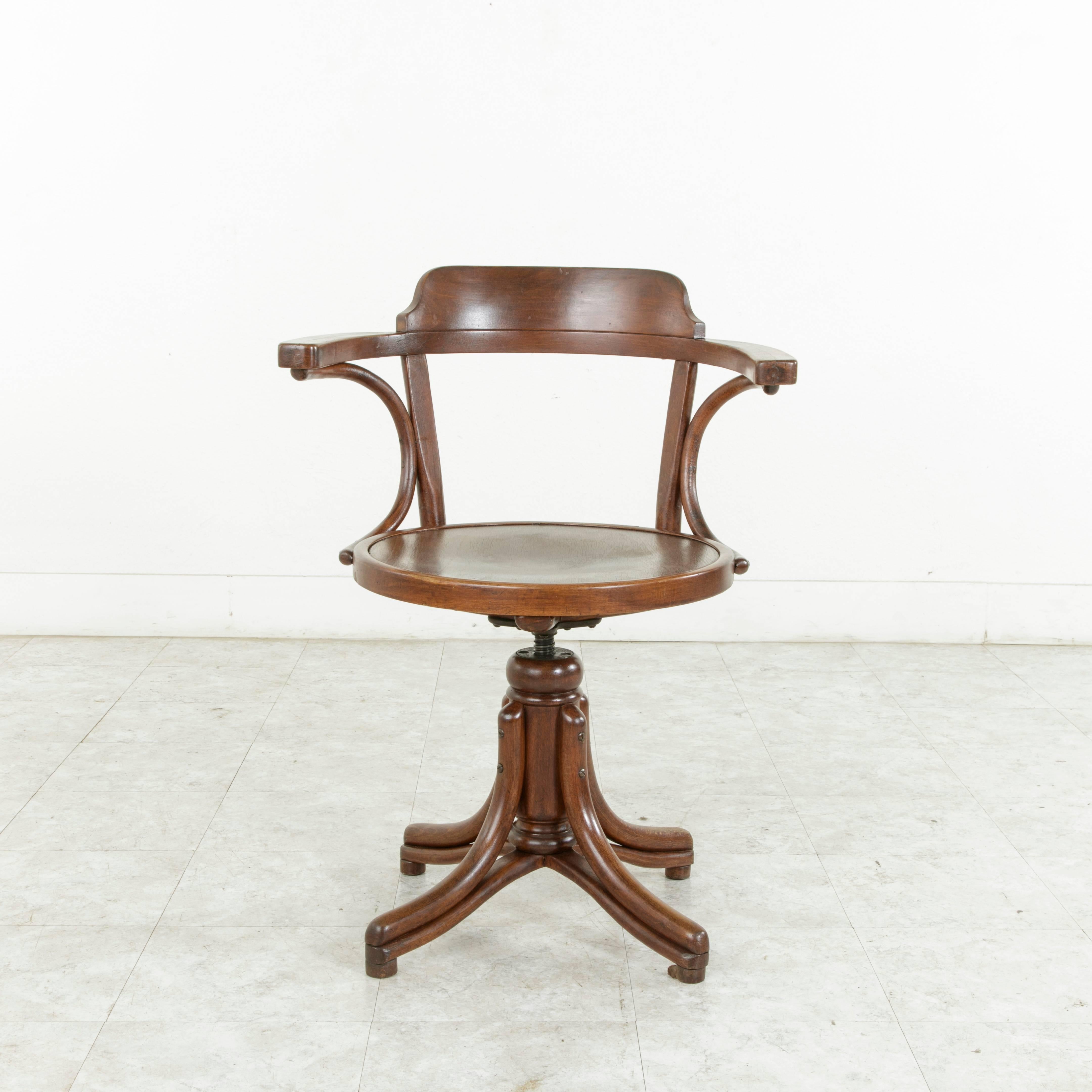 A rare find in Thonet's repertoire of chairs, this bentwood swiveling desk chair or armchair has an adjustable 18.5 to 27 inch seat height. It still bears its original Thonet sticker. The sticker includes in French, Fabricated in Czechoslovakia,
