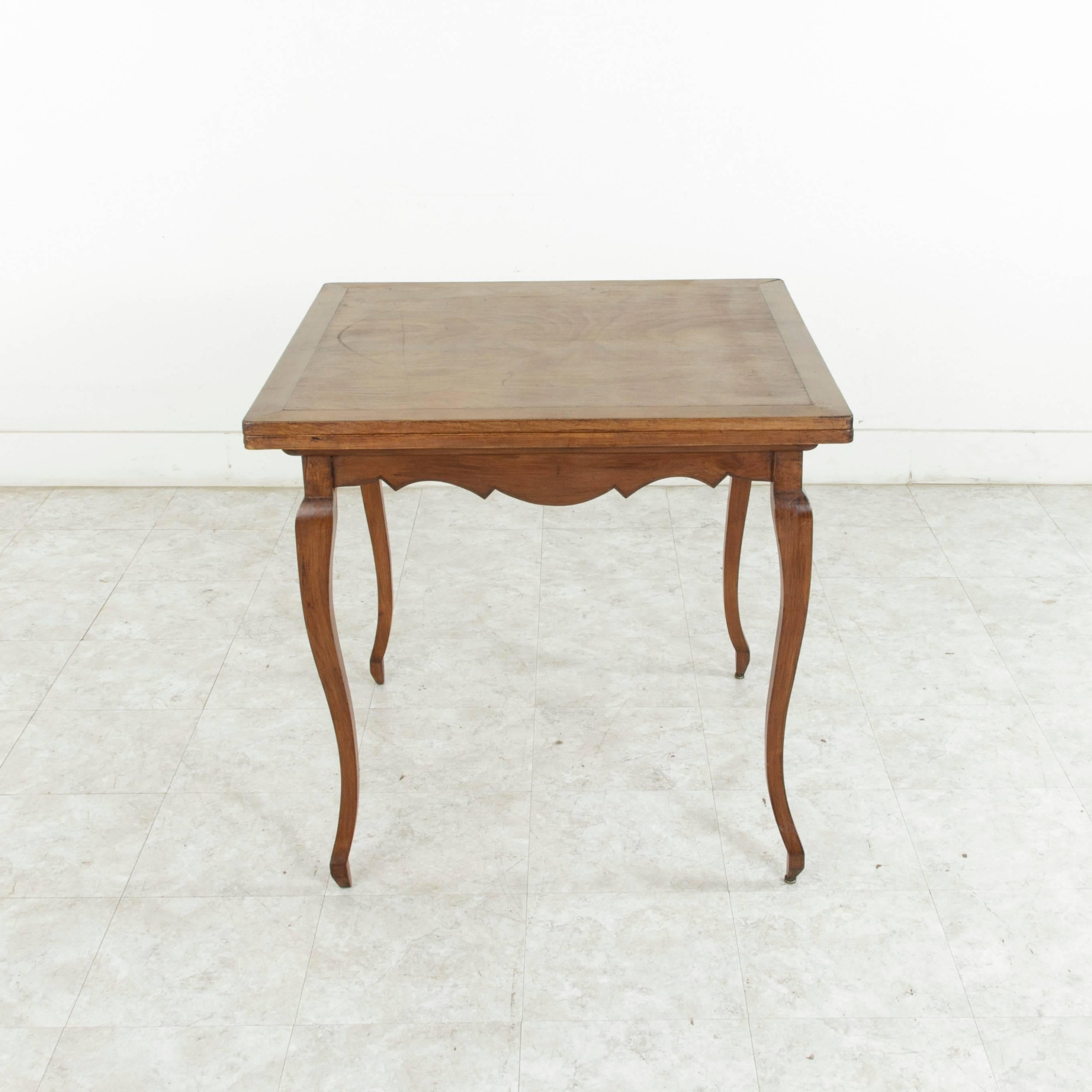 This midcentury Louis XV style cheerywood game table features a 33 inch square top that slides and unfolds to double in size with an extended tabletop length of 66 inches. Resting on Classic gently curved cabriole legs, this piece would be ideal in
