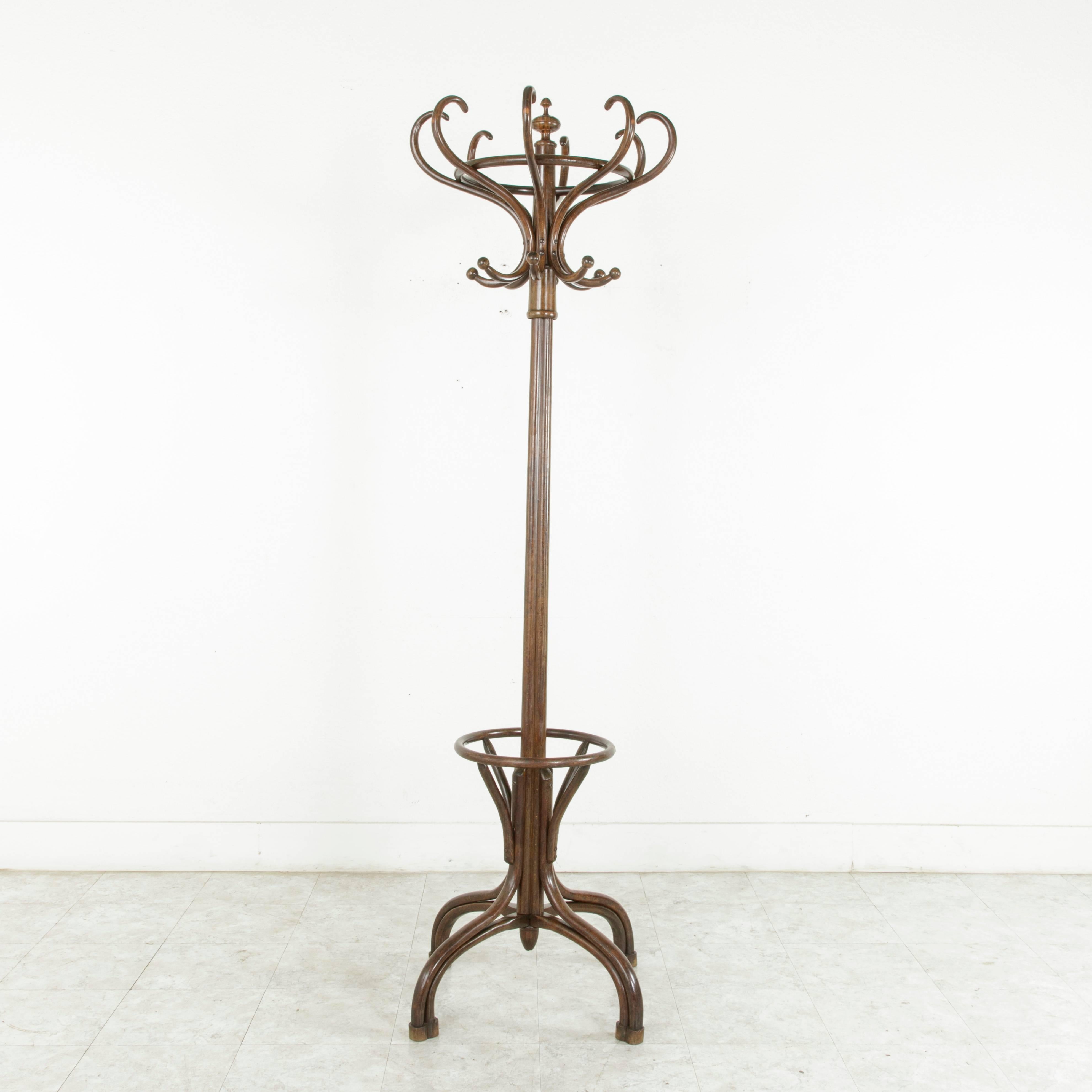 This Classic Thonet style hat and coat rack or hall tree is made of richly finished bent beechwood. It features sixteen hat and coat hooks and an umbrella holder below. A familiar fixture in the turn-of-the-century French bistro, this piece will