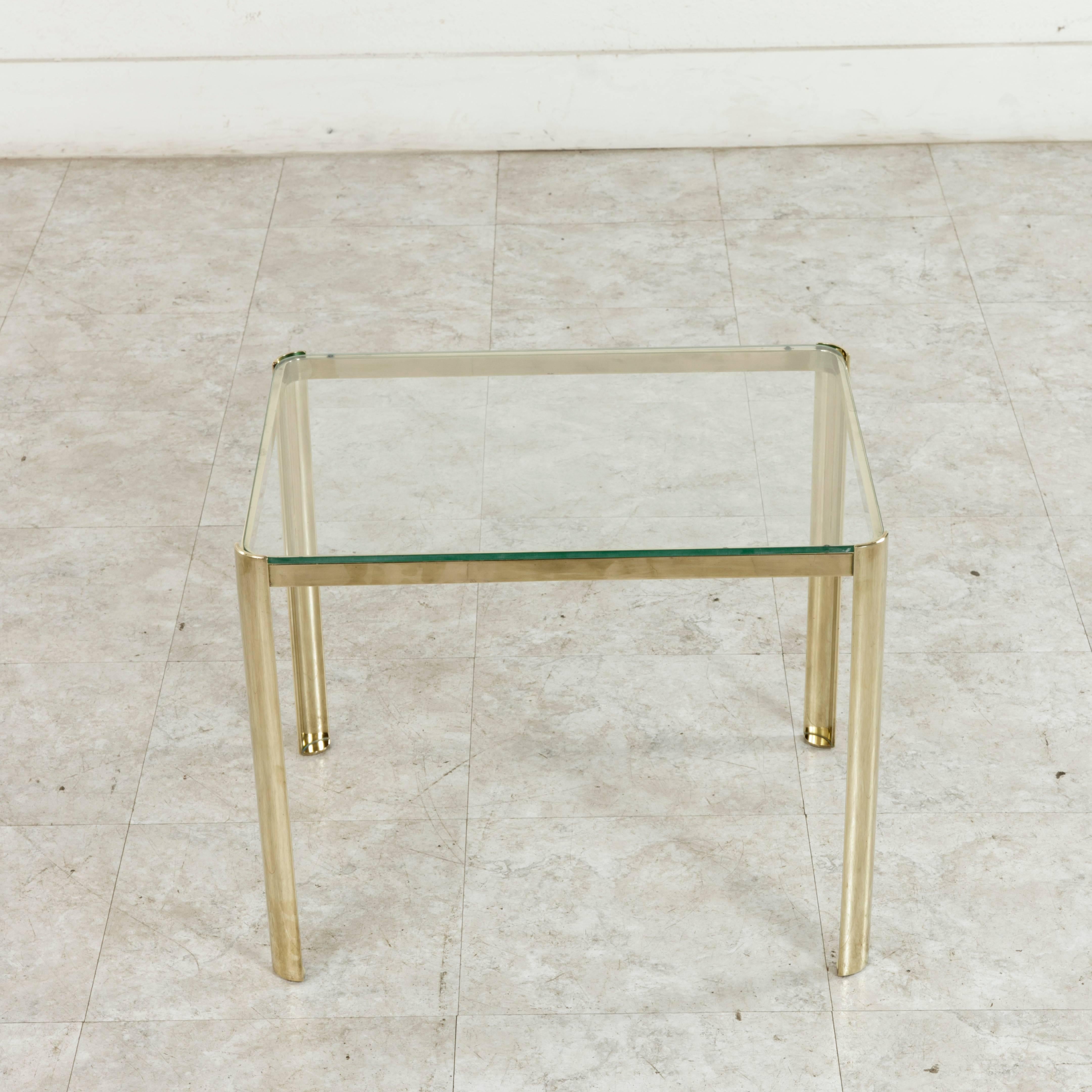 This small midcentury bronze and glass side table or cocktail table is classic 1960s Jacques Quinet. The renowned twentieth century French designer drew his inspiration from the neoclassical aesthetic in architecture and interpreted it in his own