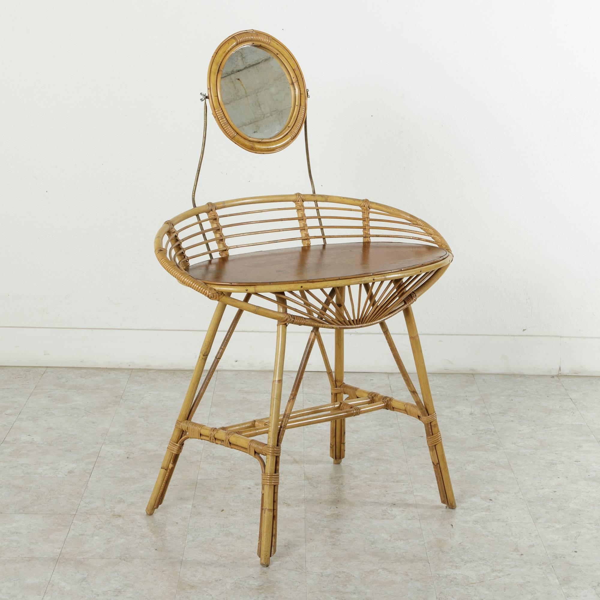 This rare and unique Art Deco bamboo table de toilette or vanity table is the perfect scale for a ladies dressing room or powder room. With an adjustable swivel mirror and a smooth tabletop, this piece could also easily serve as a petite desk or