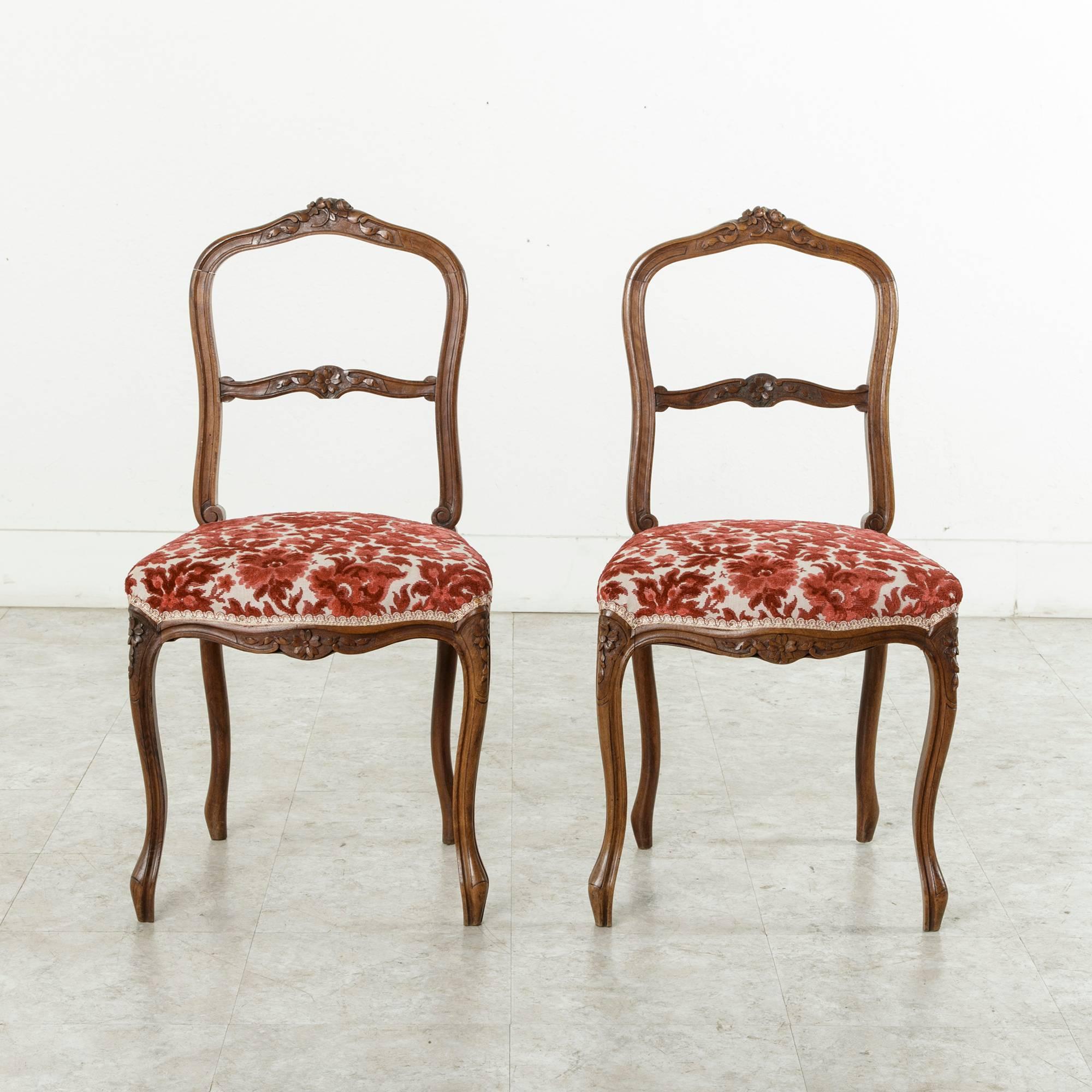 The late nineteenth century opera chair was designed to be used in the opera boxes across Europe.  The delicate lines of this fine pair do not mean delicate structure.  These chairs are sturdy, with no movement in the legs.  Upholstered in red