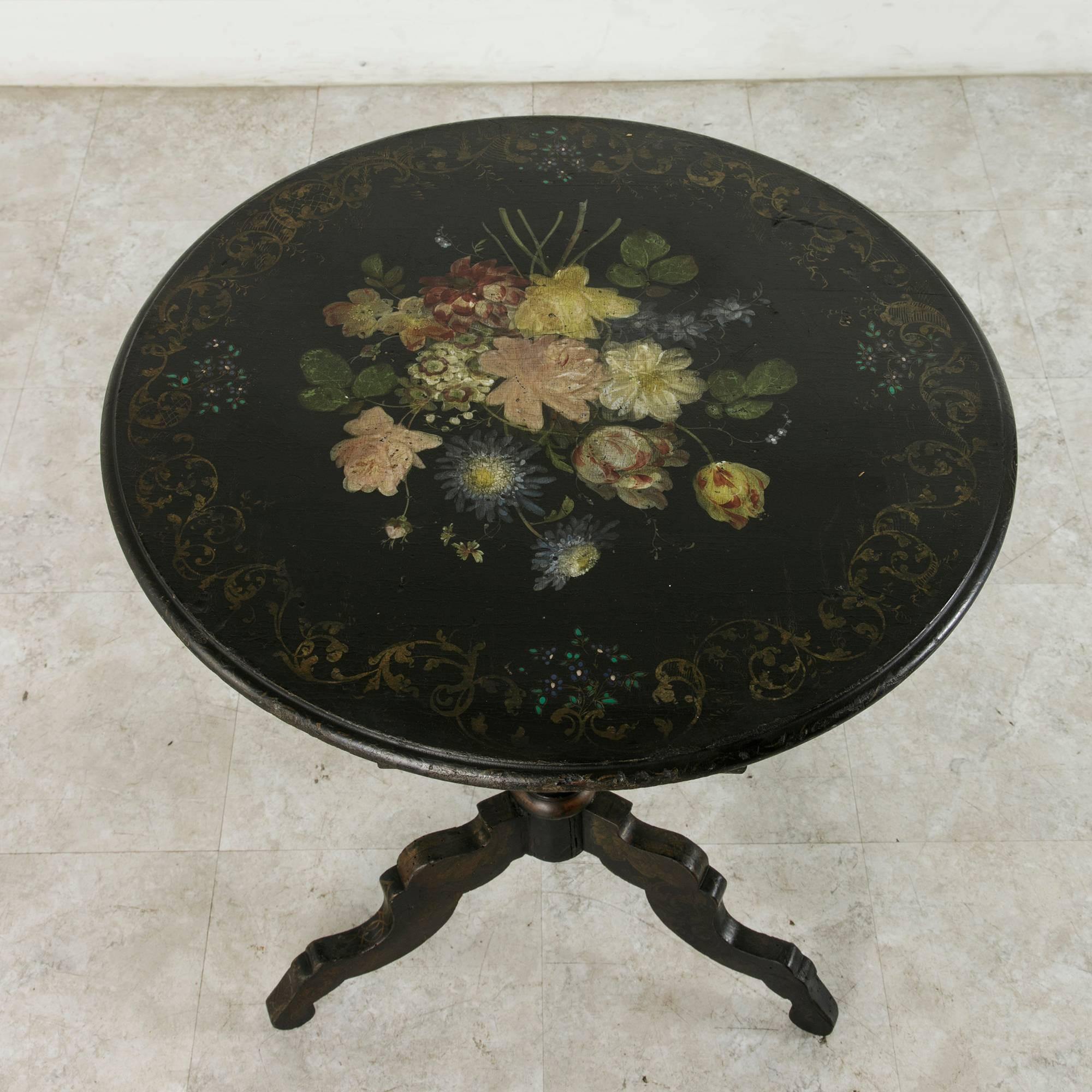 A lovely bouquet covers the top of this hand-painted Napoleon III period pedestal table, while elegant gold scroll work travels around its edge and down the turned pedestal base. A skillfully painted piece, it has aged beautifully and will lend a