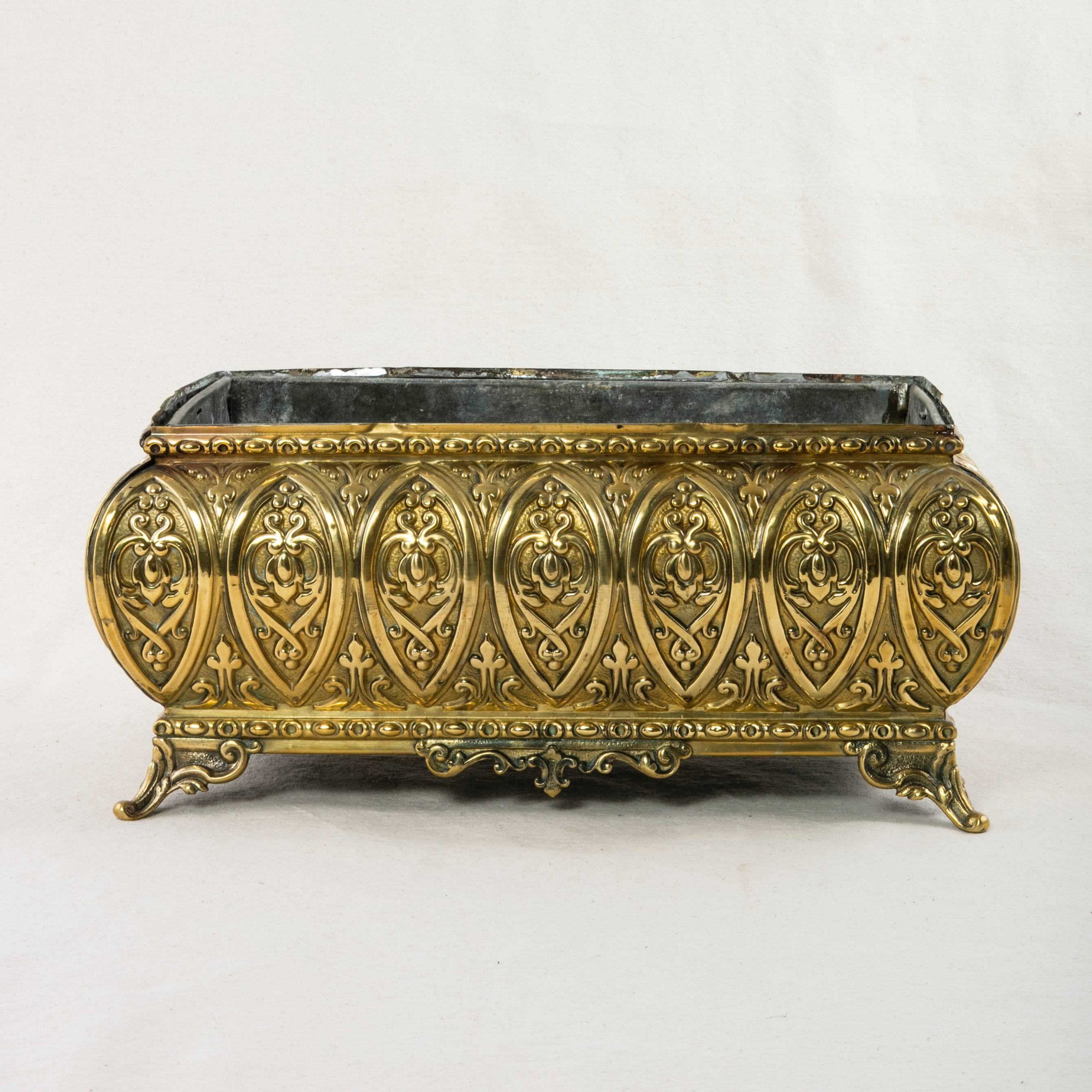 This brass repoussé jardinière or cachepot features bombe sides and its decorative relief on all four sides. Includes its original zinc liner, circa 1900.
