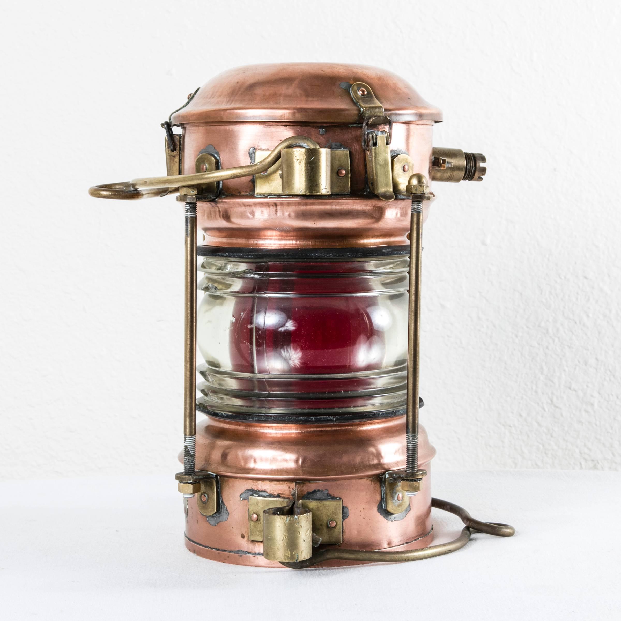 This large classic 19th century copper and brass nautical lantern features the label of its maker in St. Ouen, near Paris. Used on a river boat, its beautifully aged copper and brass shine brightly and its original red glass, for the starboard side,