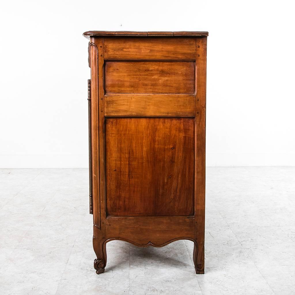 This elbow height buffet is the perfect scale for use as a bar or serving piece. Hand-carved and hand pegged in solid cherrywood, this piece was created in Normandy circa 1900. Its simple floral carvings give it a wonderful warm country feel, while